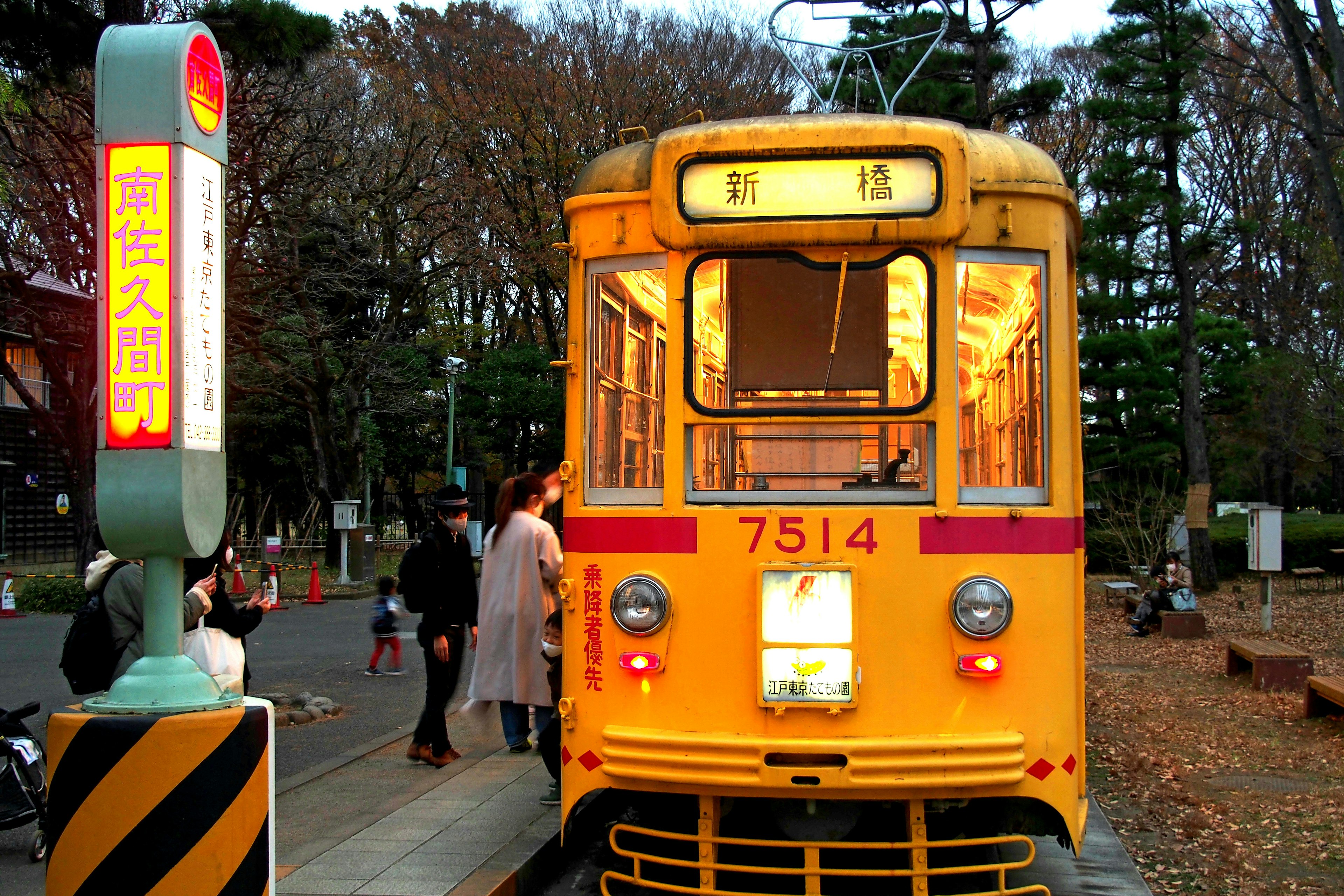 Tram jaune avec des personnes dans un parc