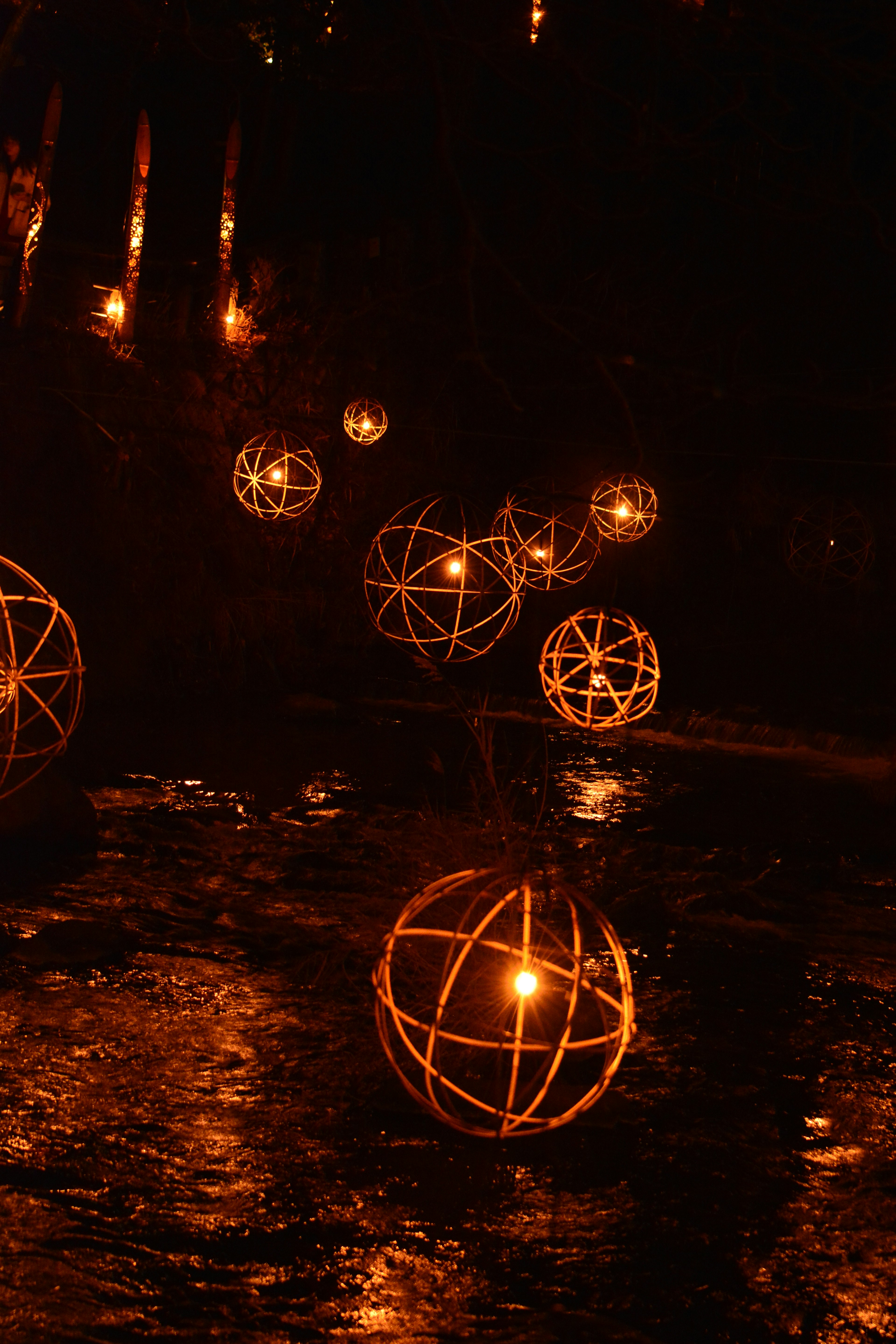 Decoraciones esféricas iluminadas flotando sobre una superficie de agua oscura