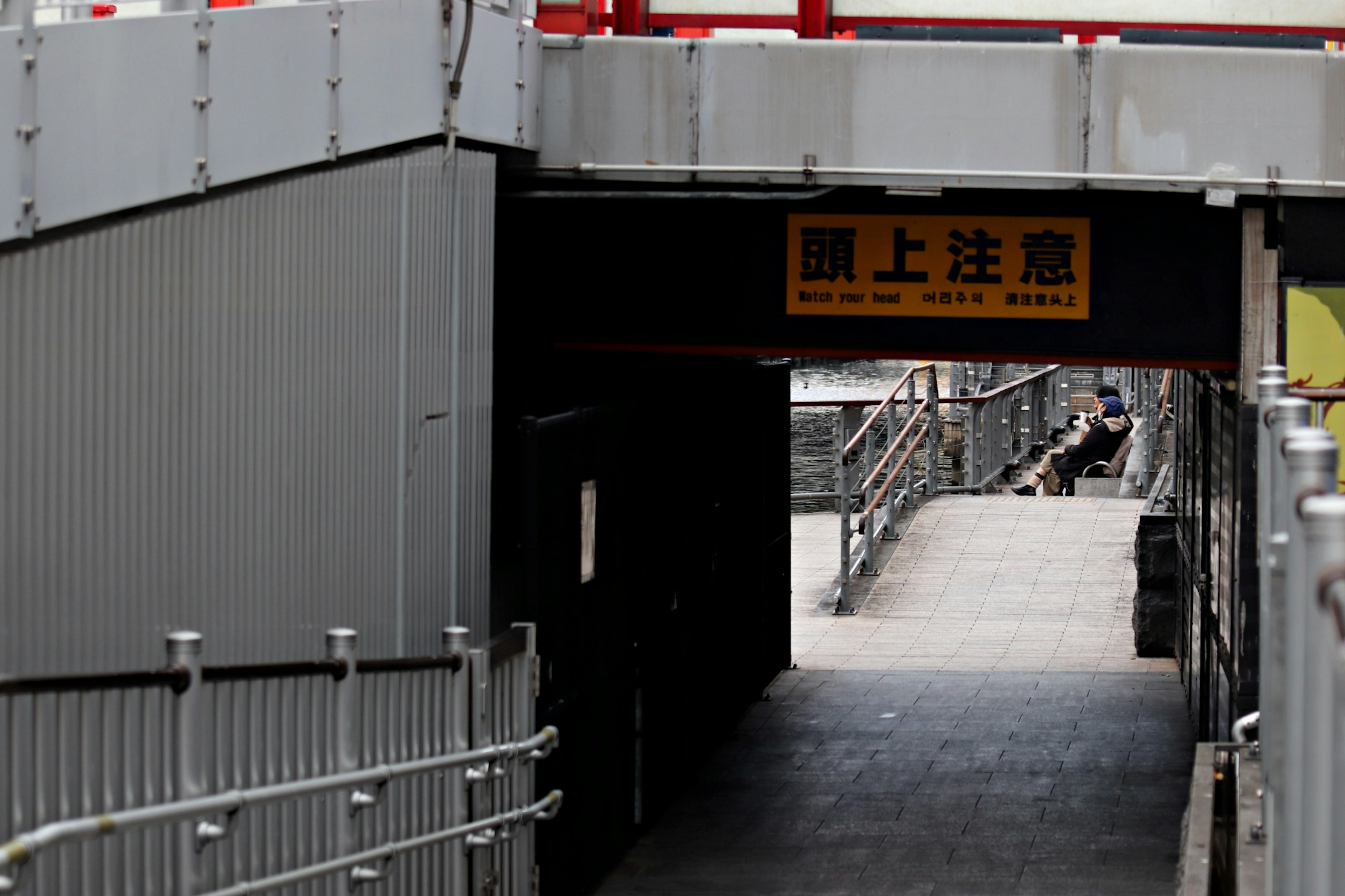 Entrada a un túnel con un letrero amarillo y estructuras circundantes