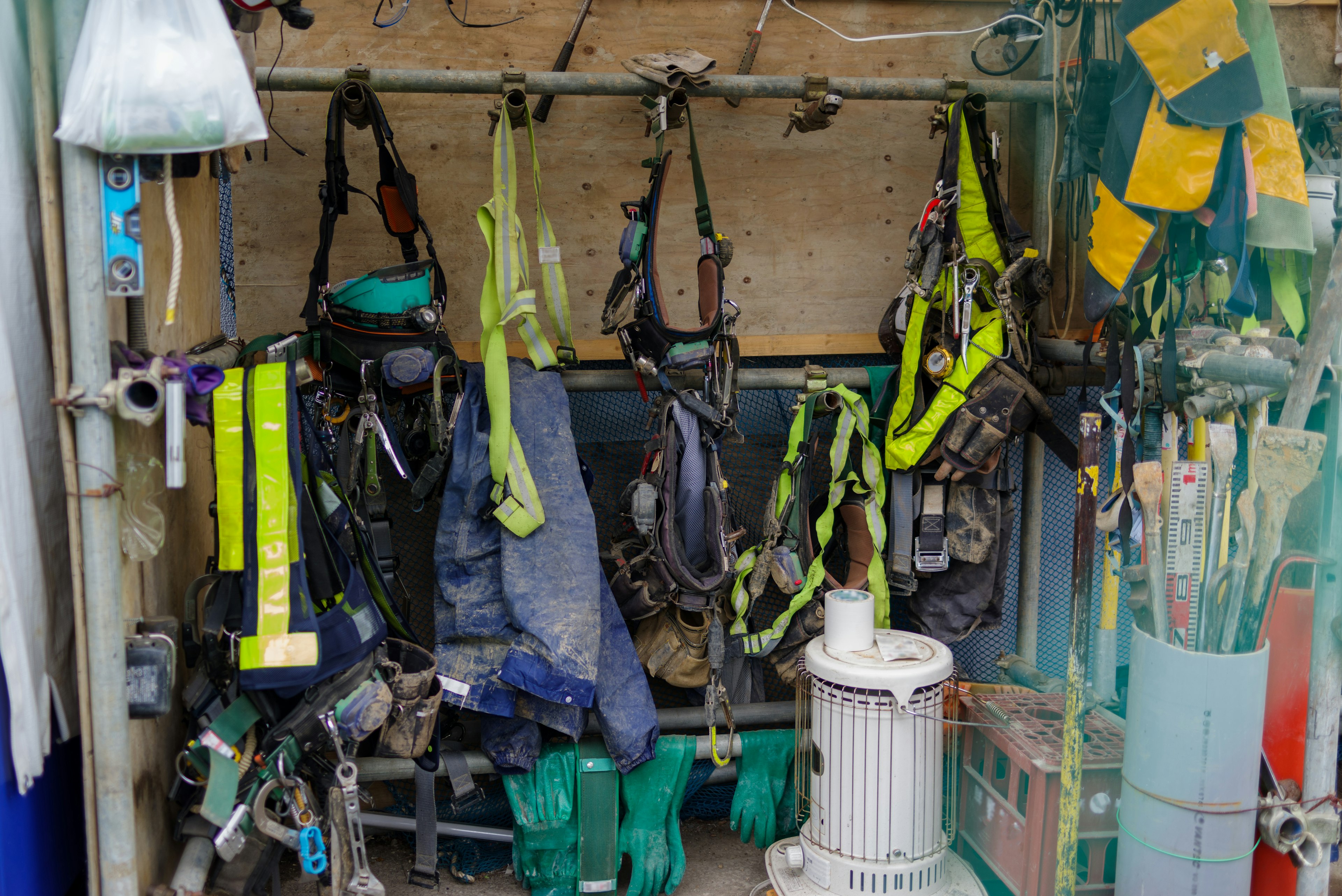 Corner of a workspace with safety harnesses and gear hanging