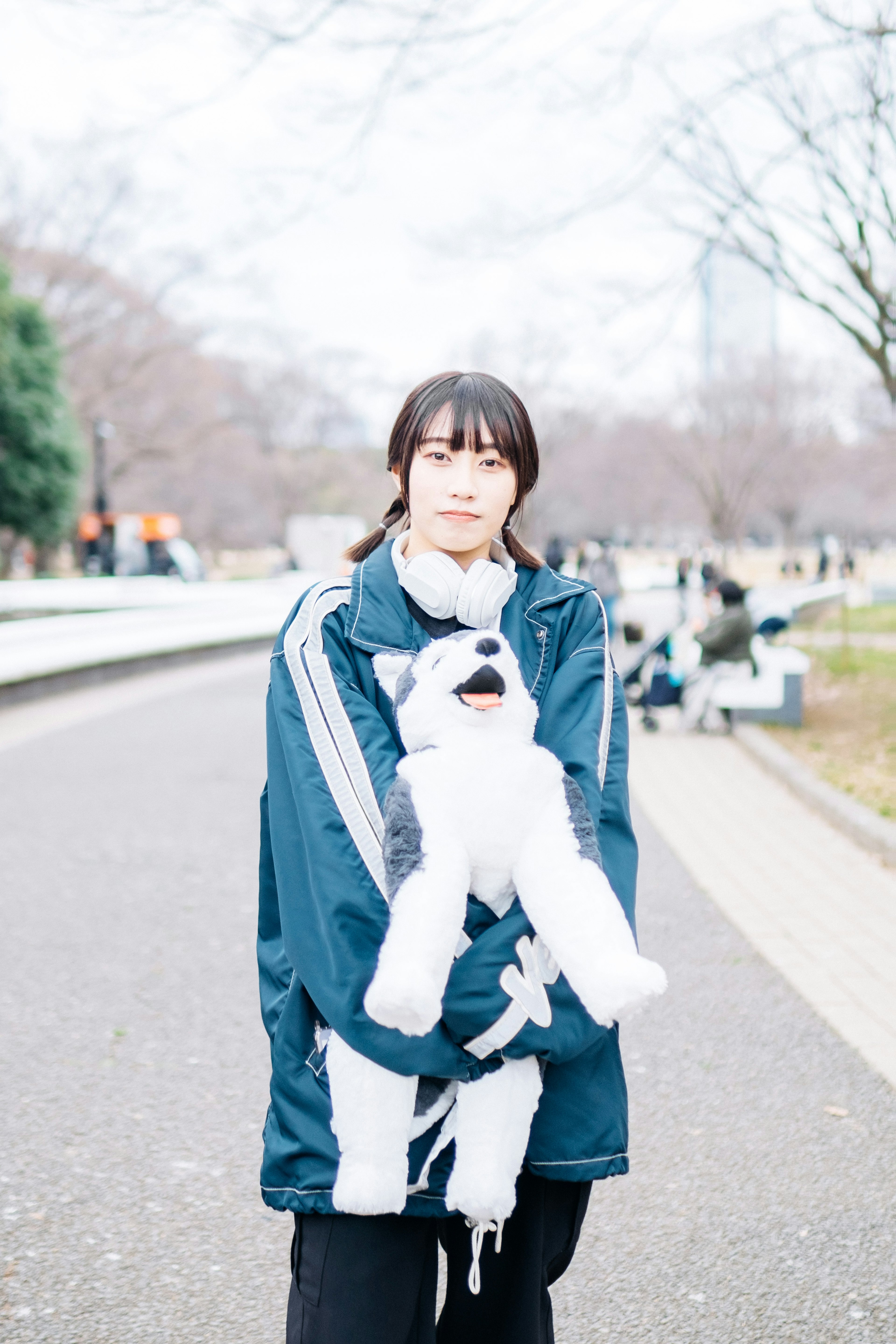 公園でぬいぐるみの犬を抱えた女性