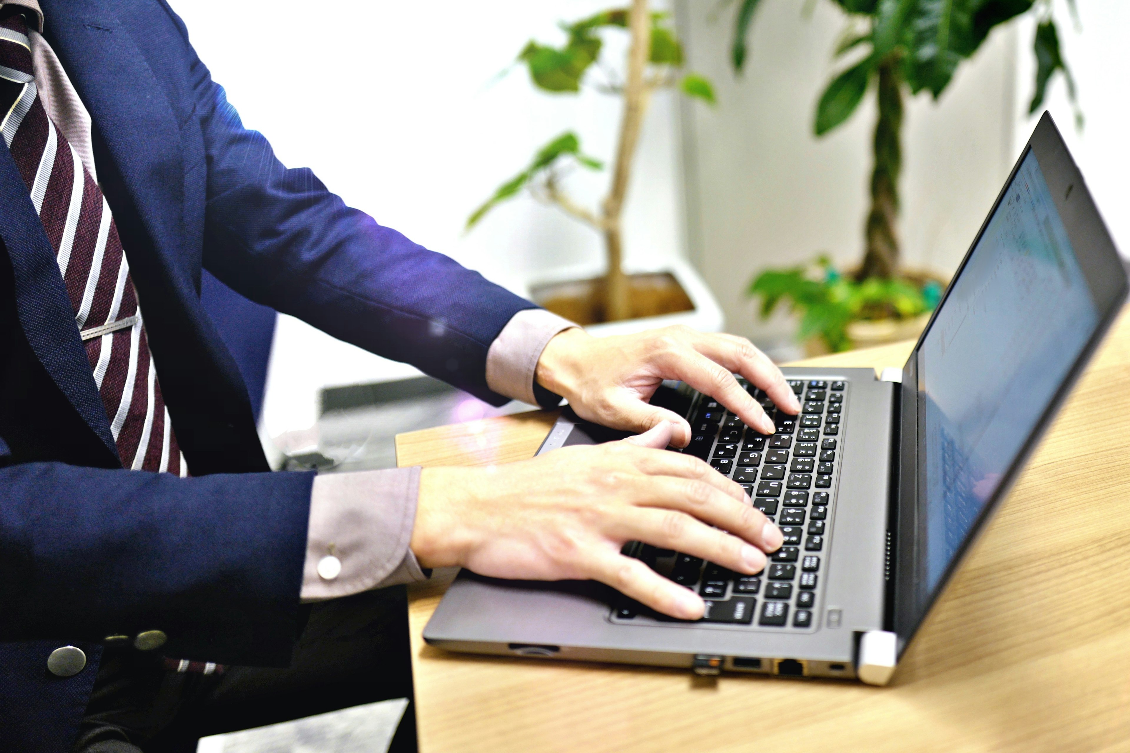 Businessman typing on a laptop in an office setting