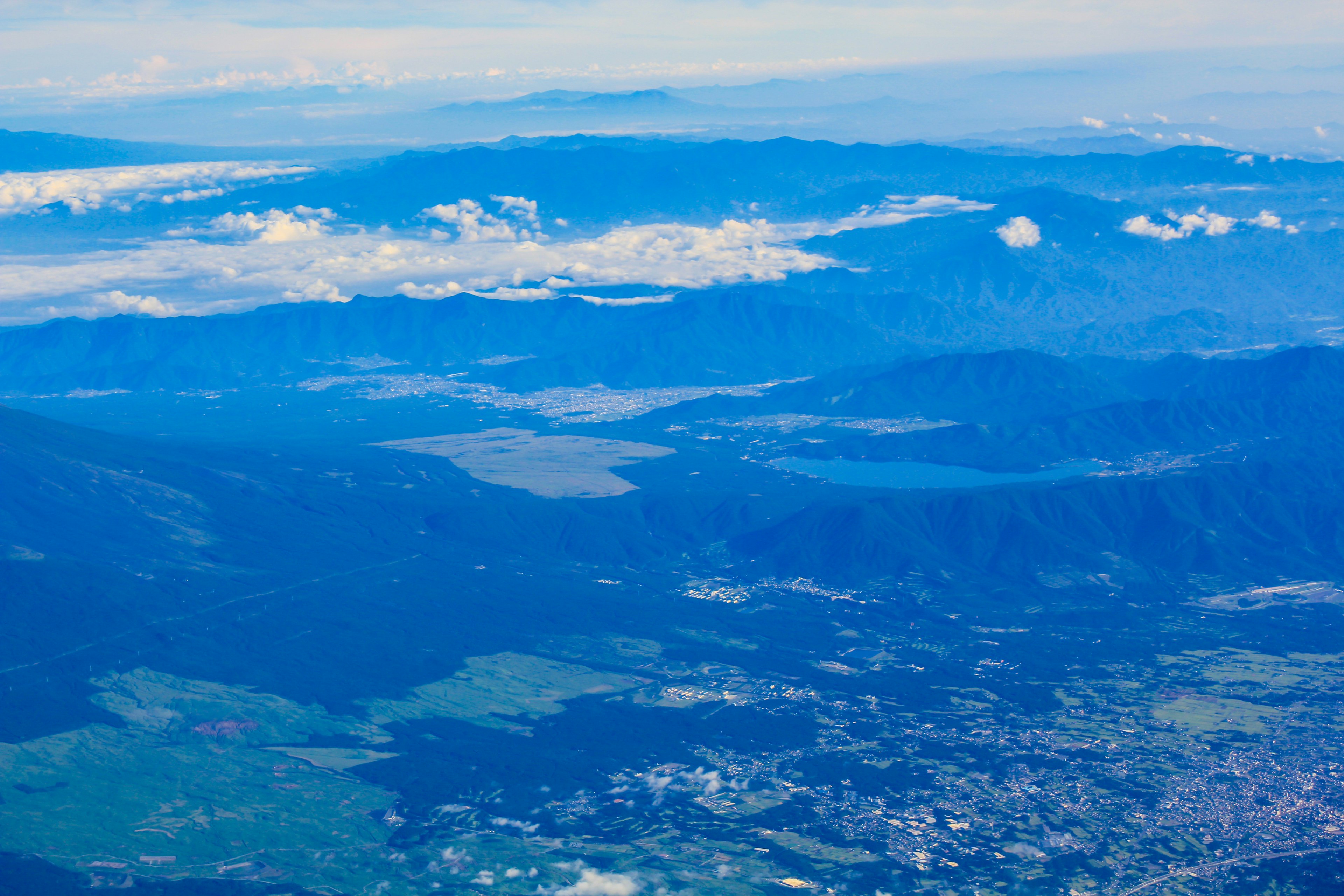 Pemandangan udara pegunungan biru dan awan di bawah langit yang cerah