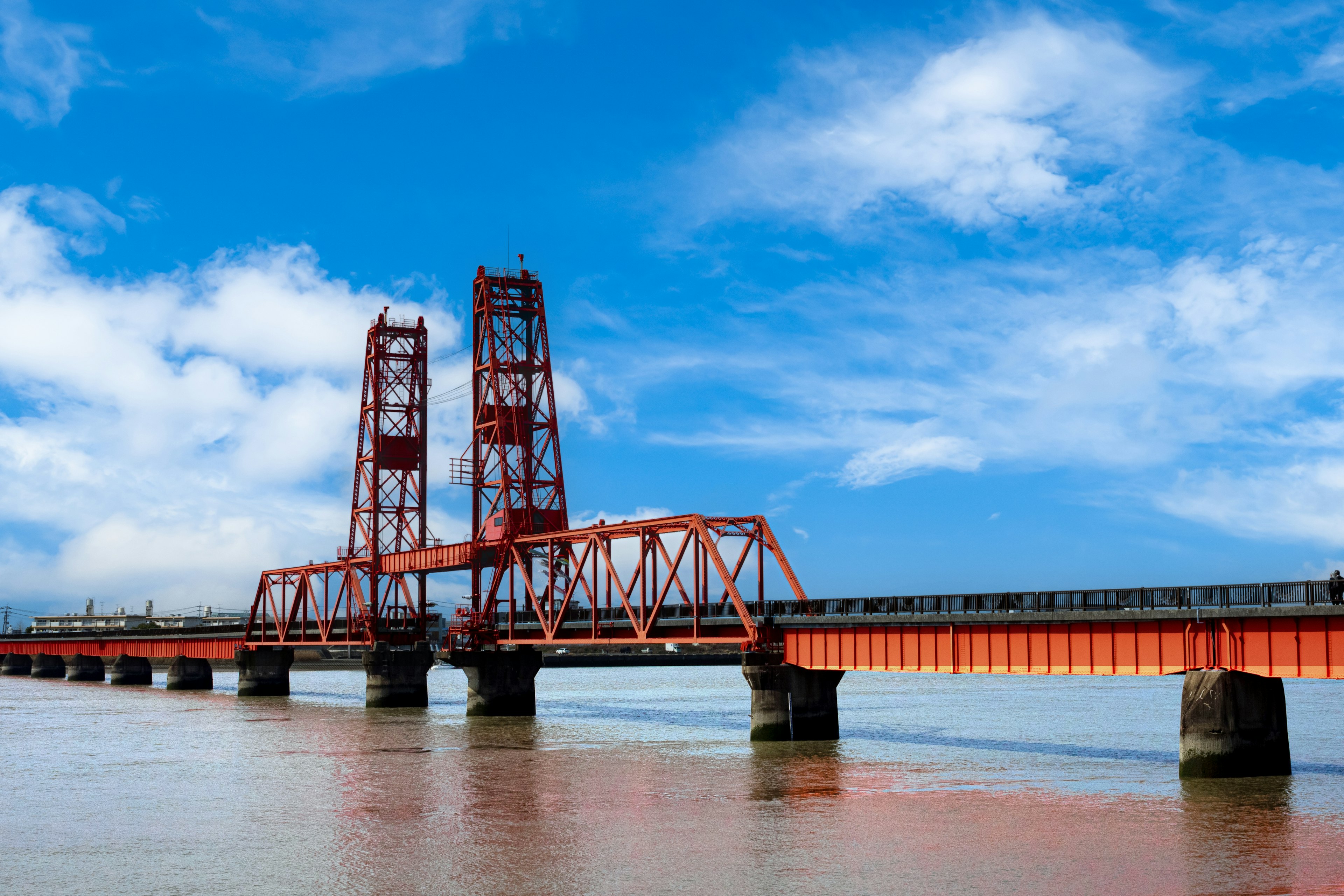 Pont levant rouge s'étendant sur l'eau sous un ciel bleu