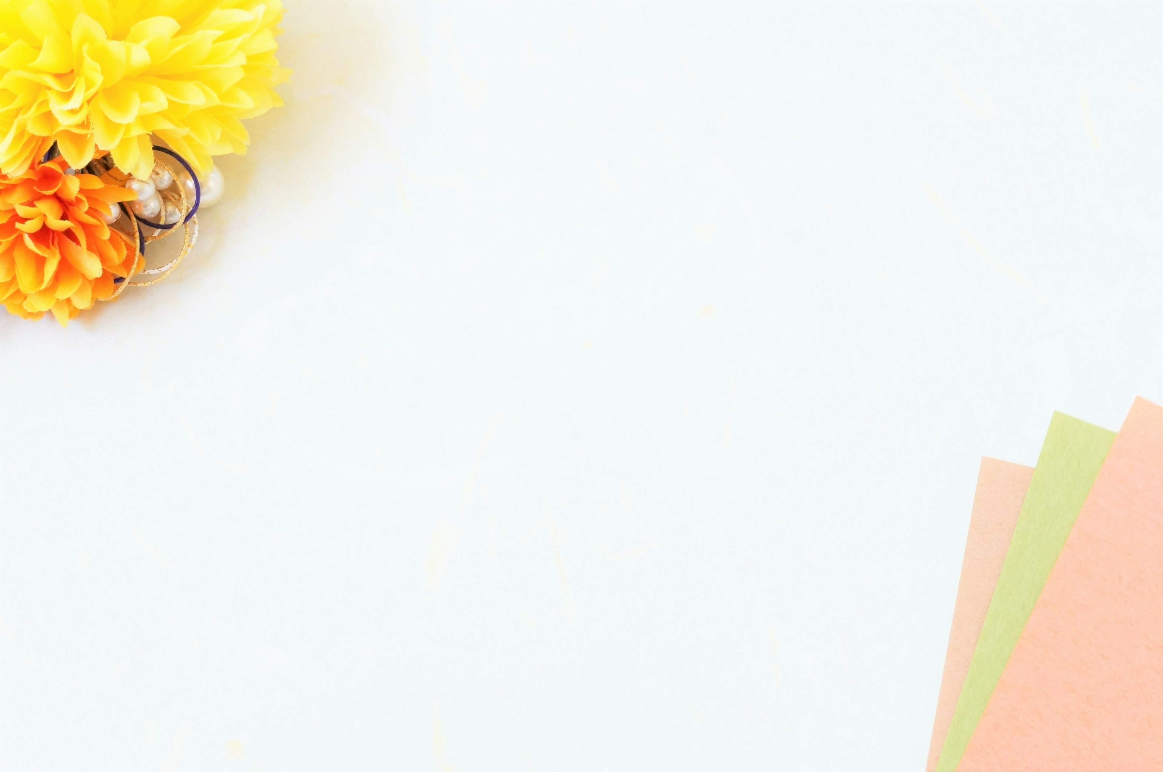 Image featuring yellow and orange flowers on a white background with colorful paper sheets