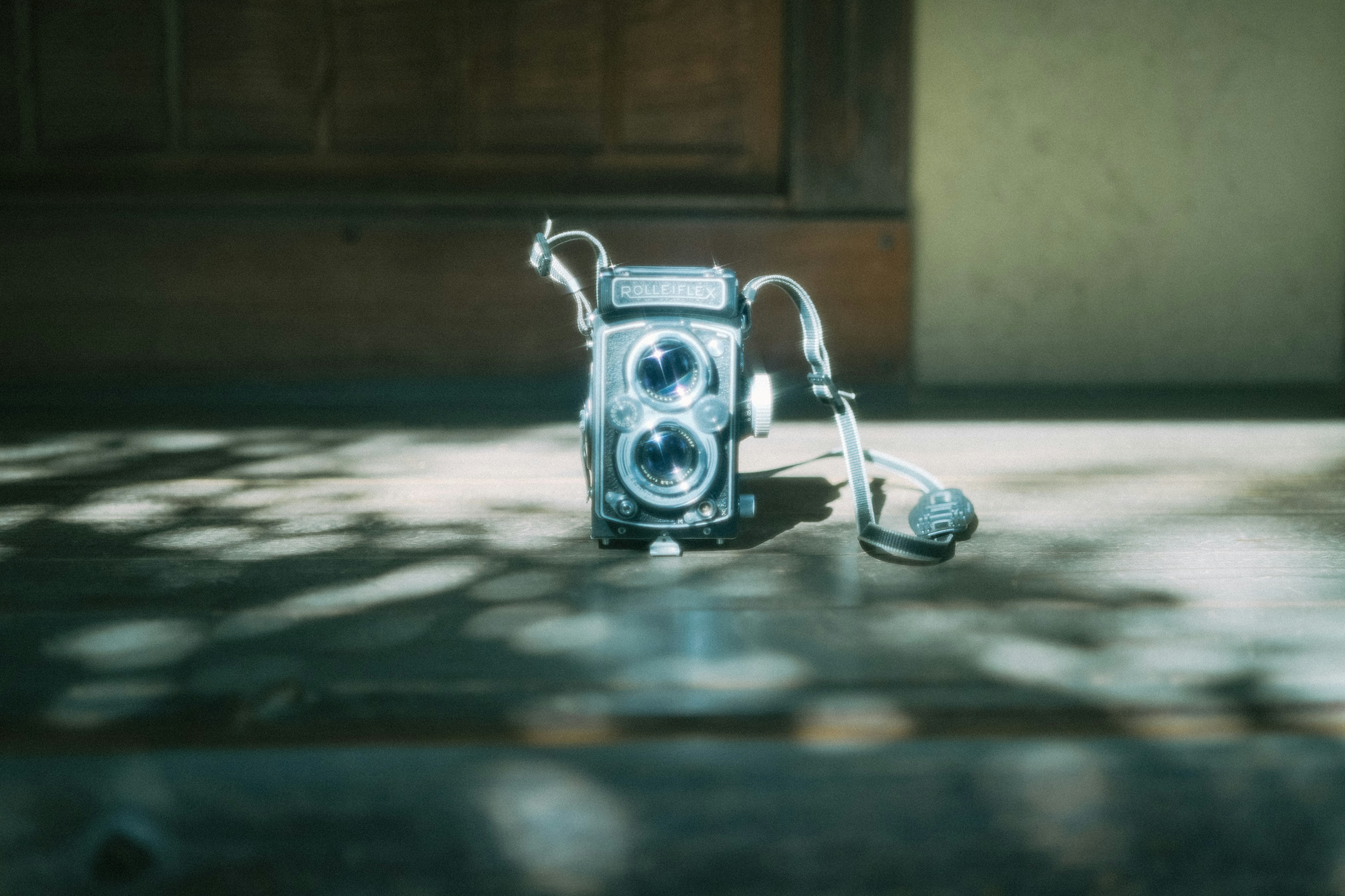 An old twin-lens camera placed on a wooden floor with soft light