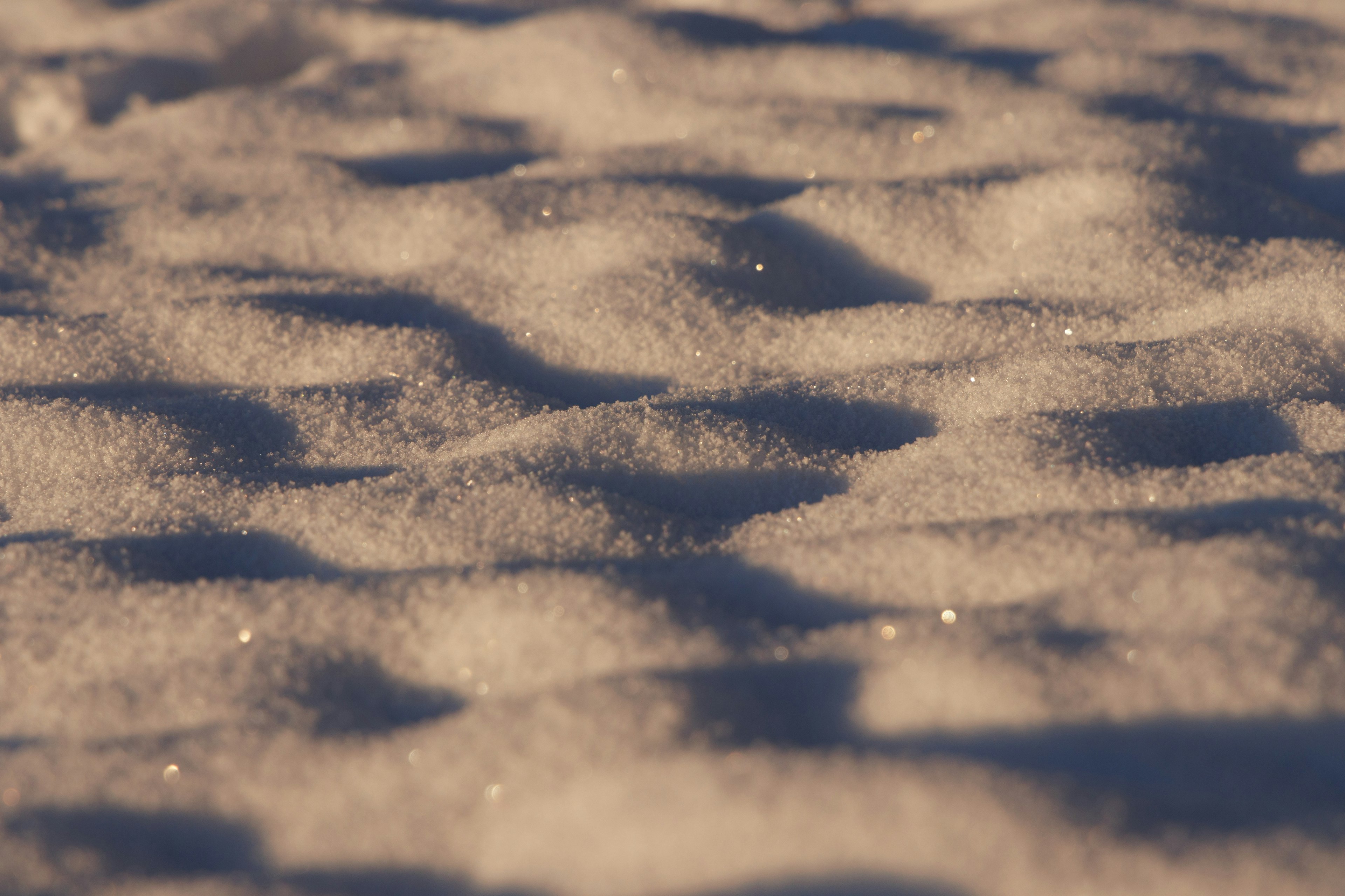 Gros plan sur une surface enneigée avec des particules scintillantes et des motifs en vagues