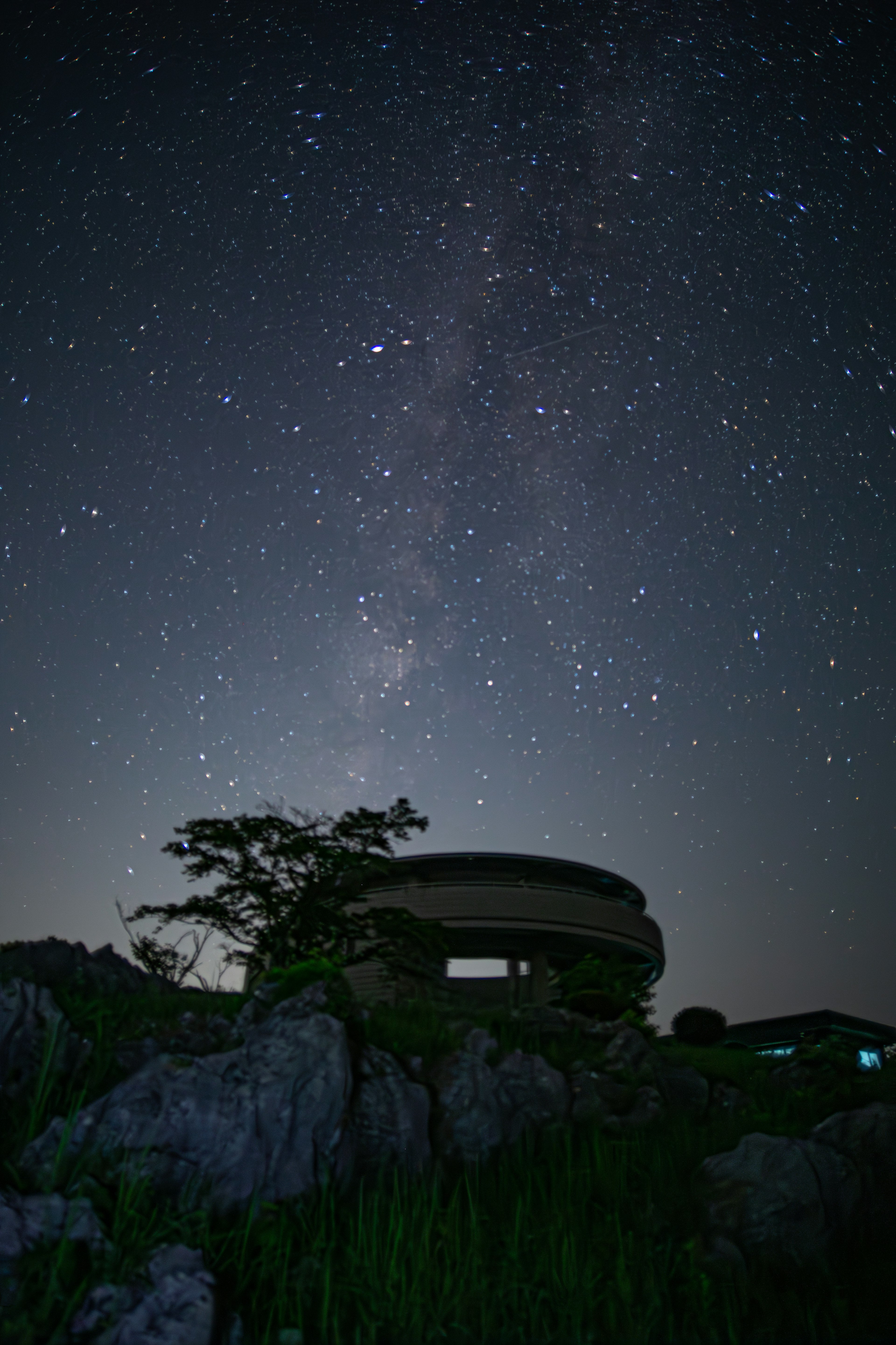 Silhouette di un edificio e rocce sotto un cielo stellato