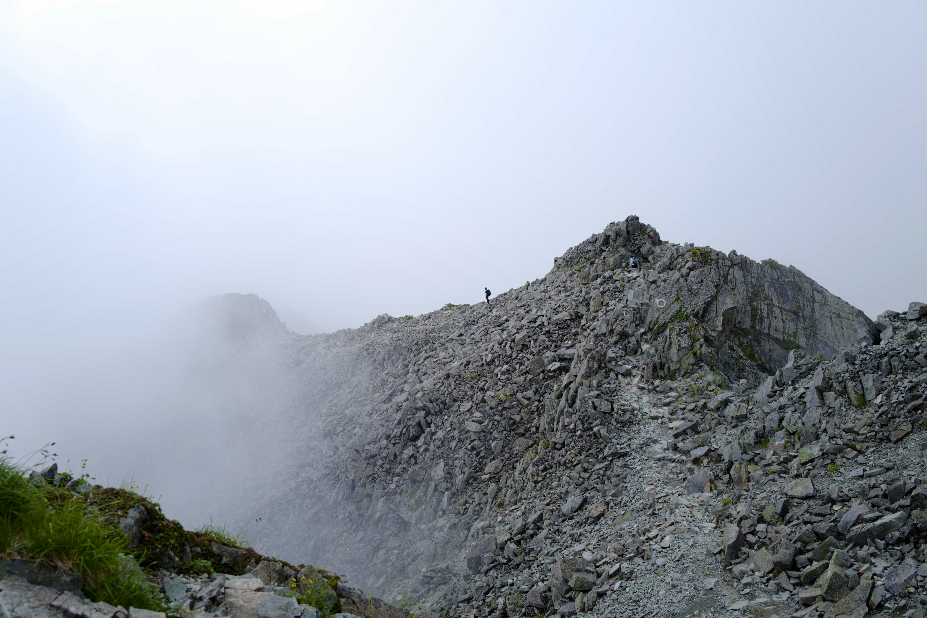 Paisaje montañoso envuelto en niebla con pendientes rocosos