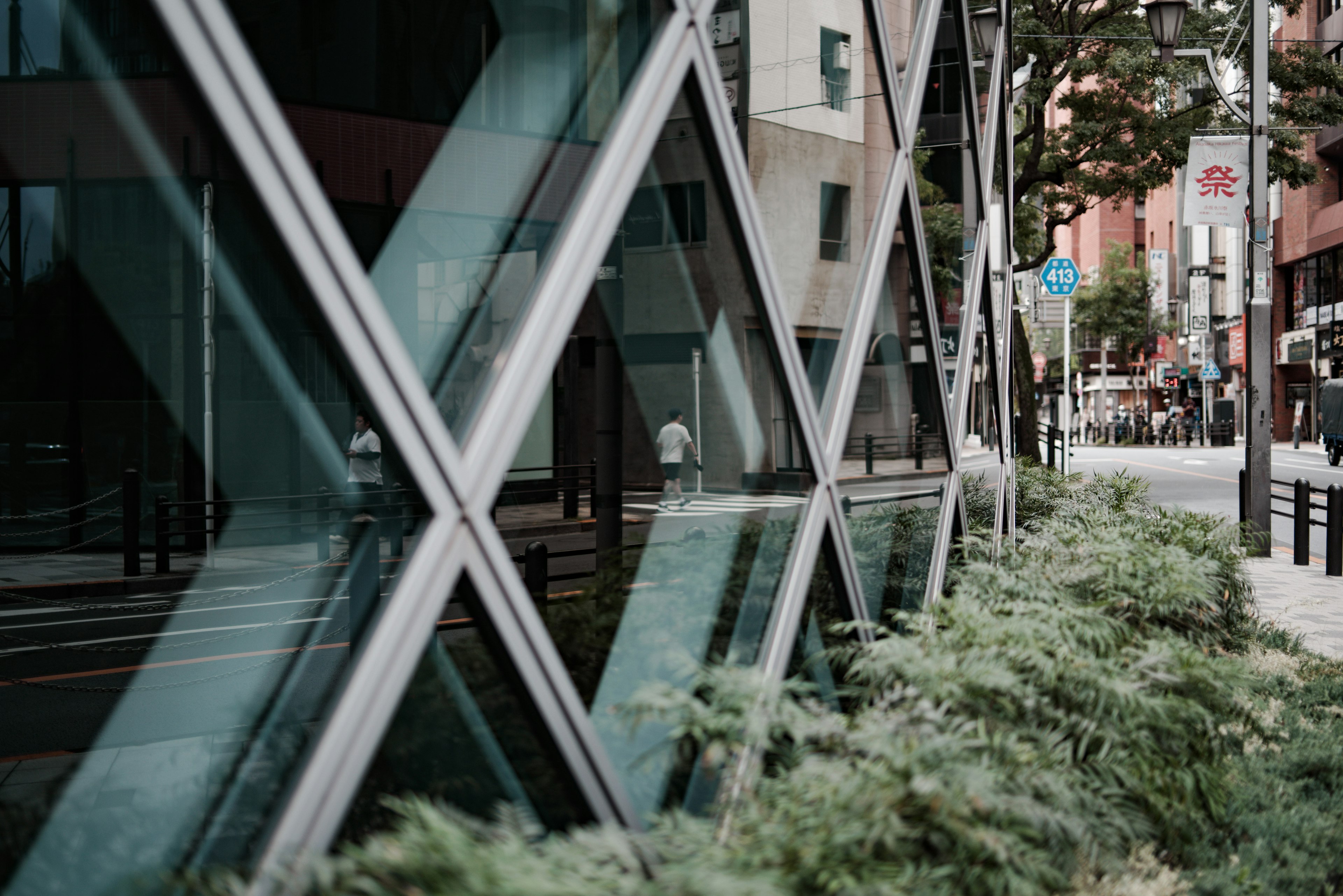 Edificio moderno que refleja el entorno urbano con vegetación