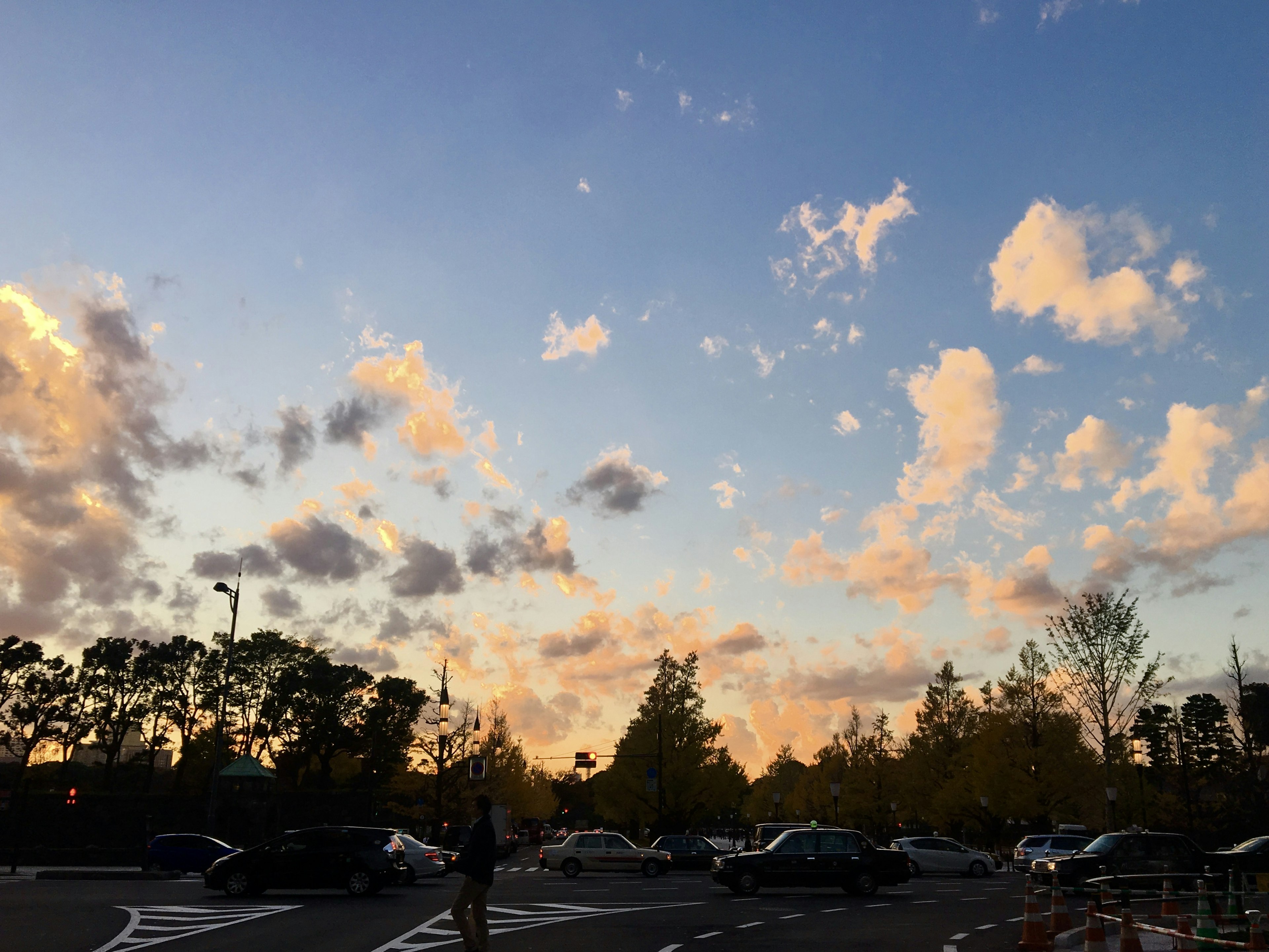 夕焼けの空と雲が広がる風景 駐車場に車が並ぶ