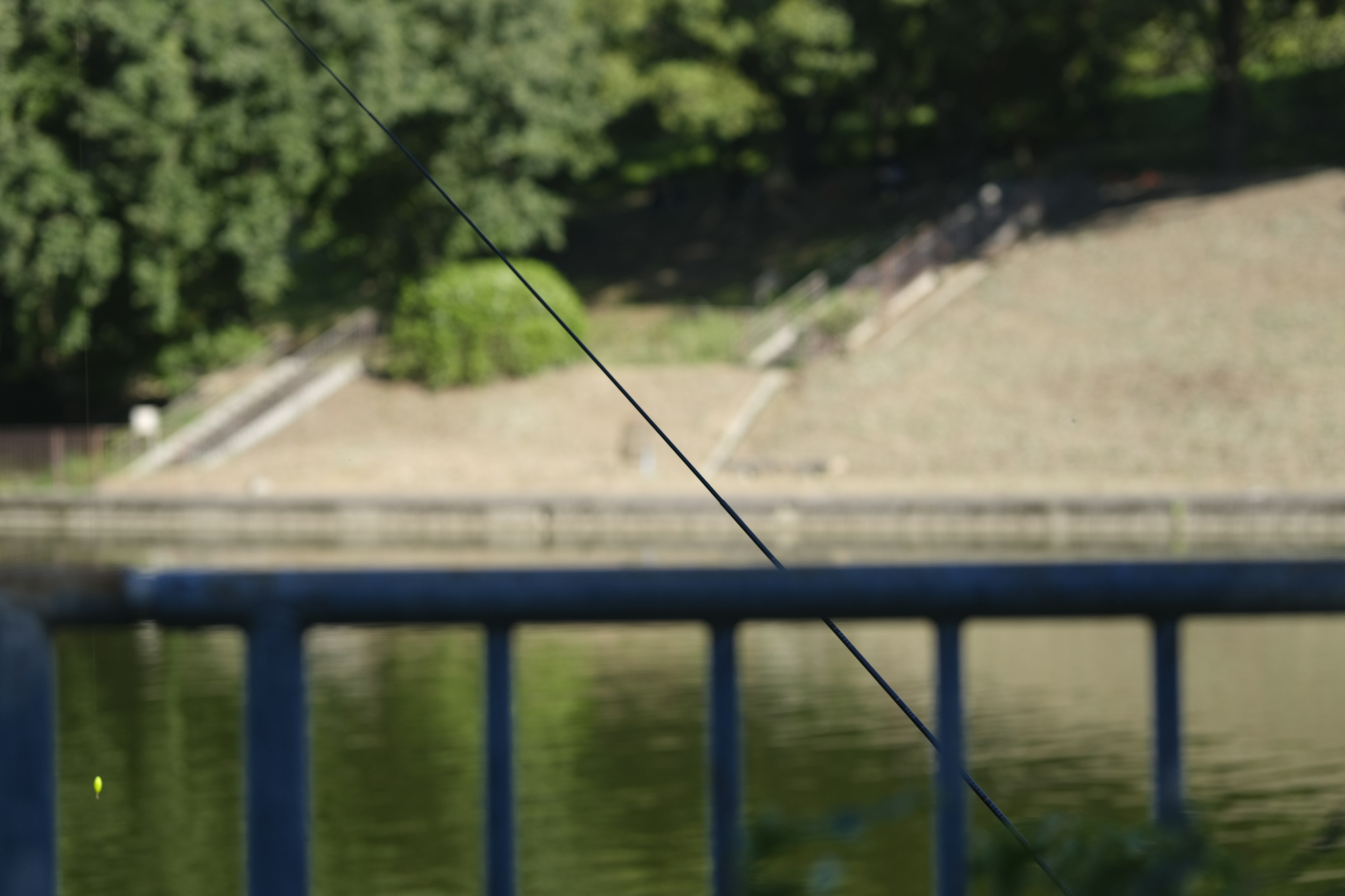 Railing blu vicino a un lago con sfondo sfocato