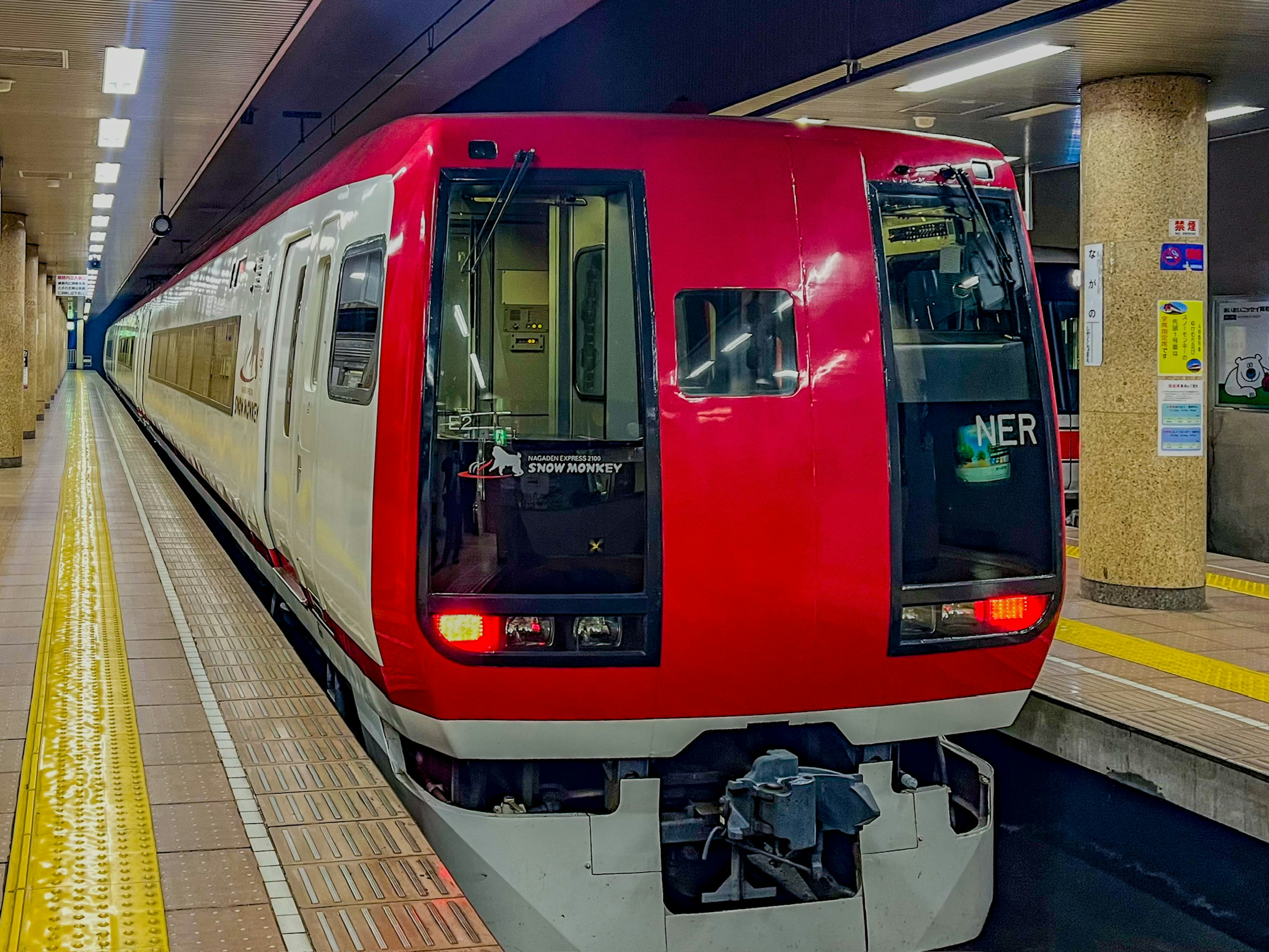 Red train parked at a subway station platform