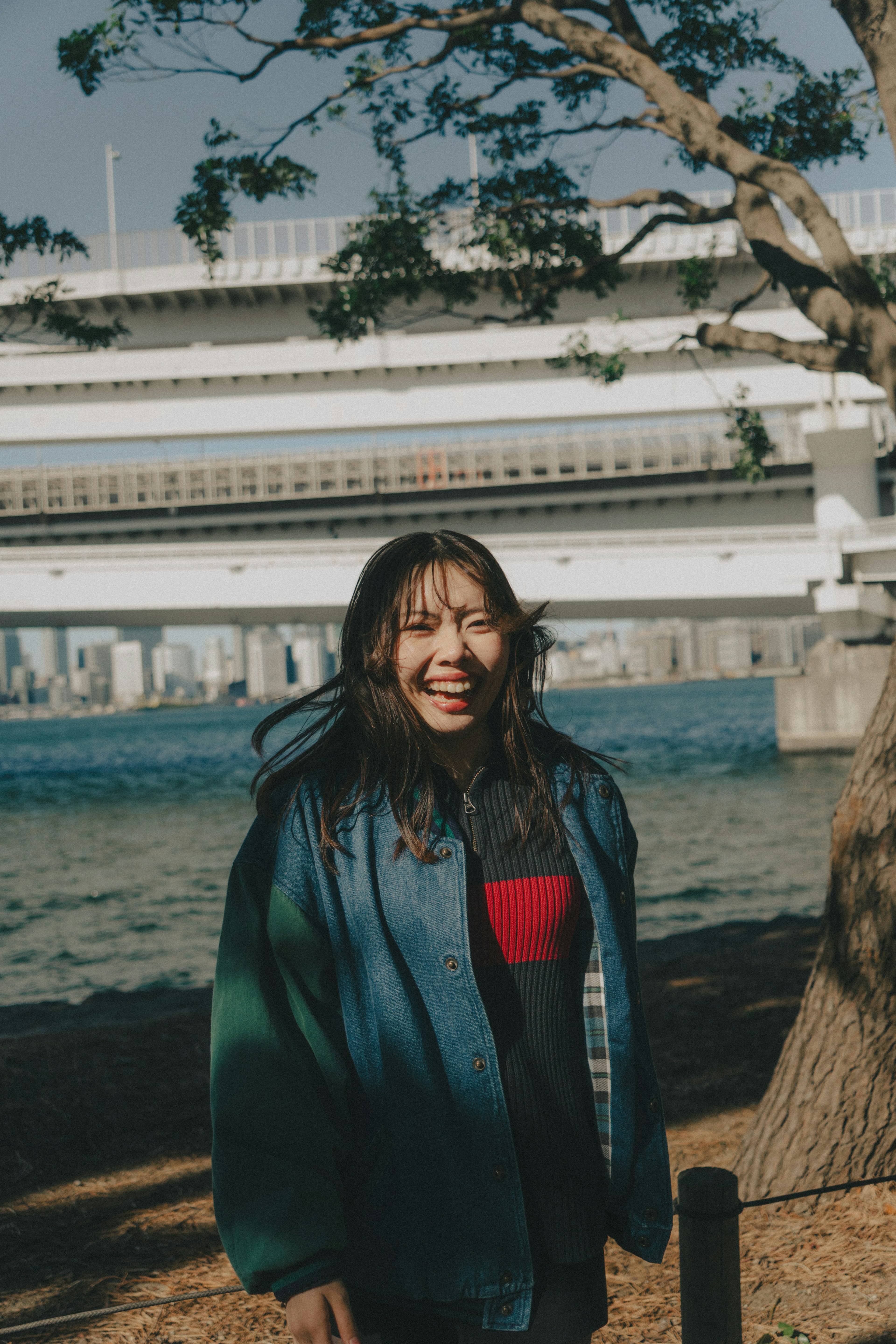 Una donna sorridente in abbigliamento casual che sta vicino a un fiume