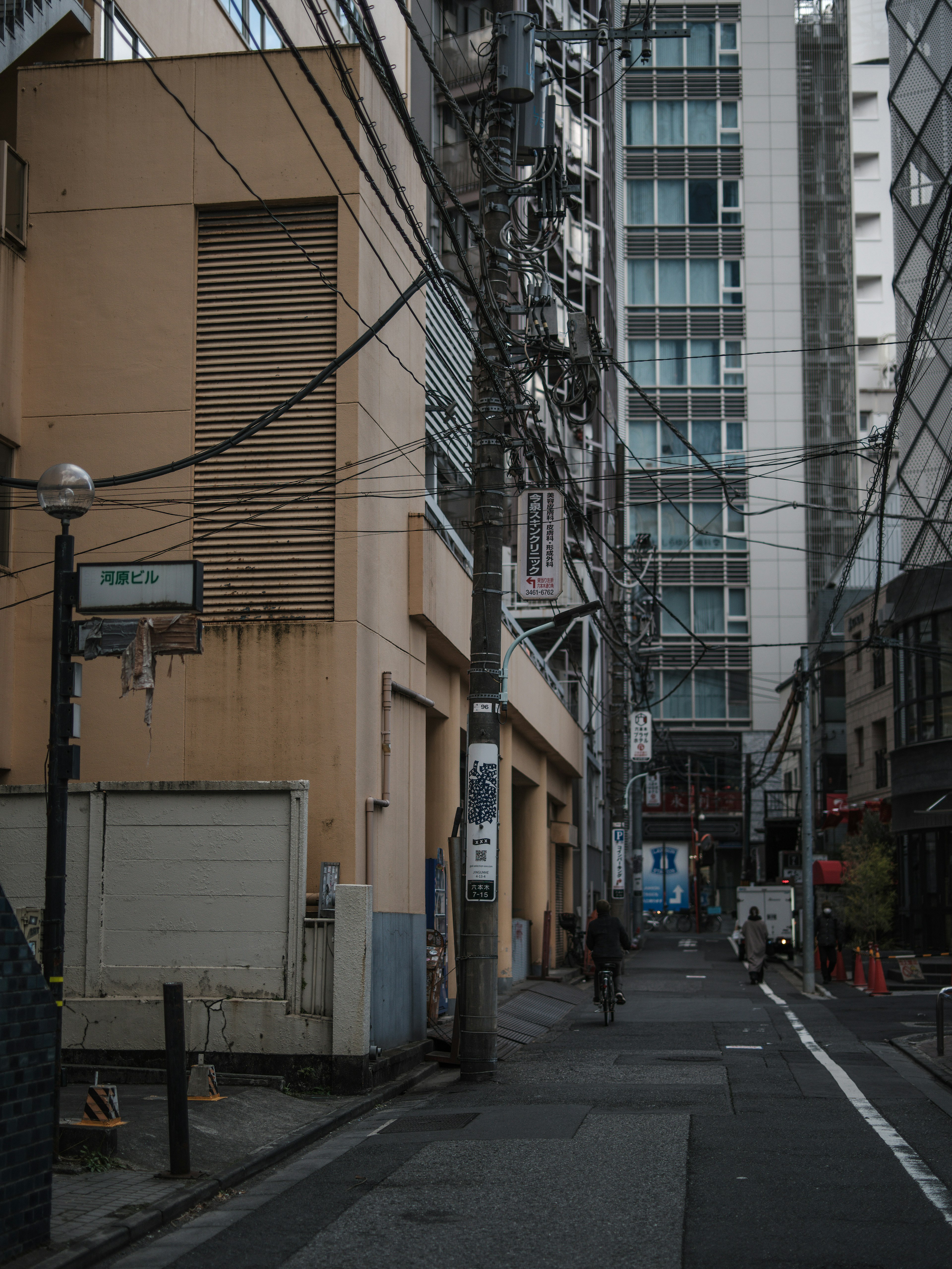 Narrow alley featuring buildings and power lines in an urban setting