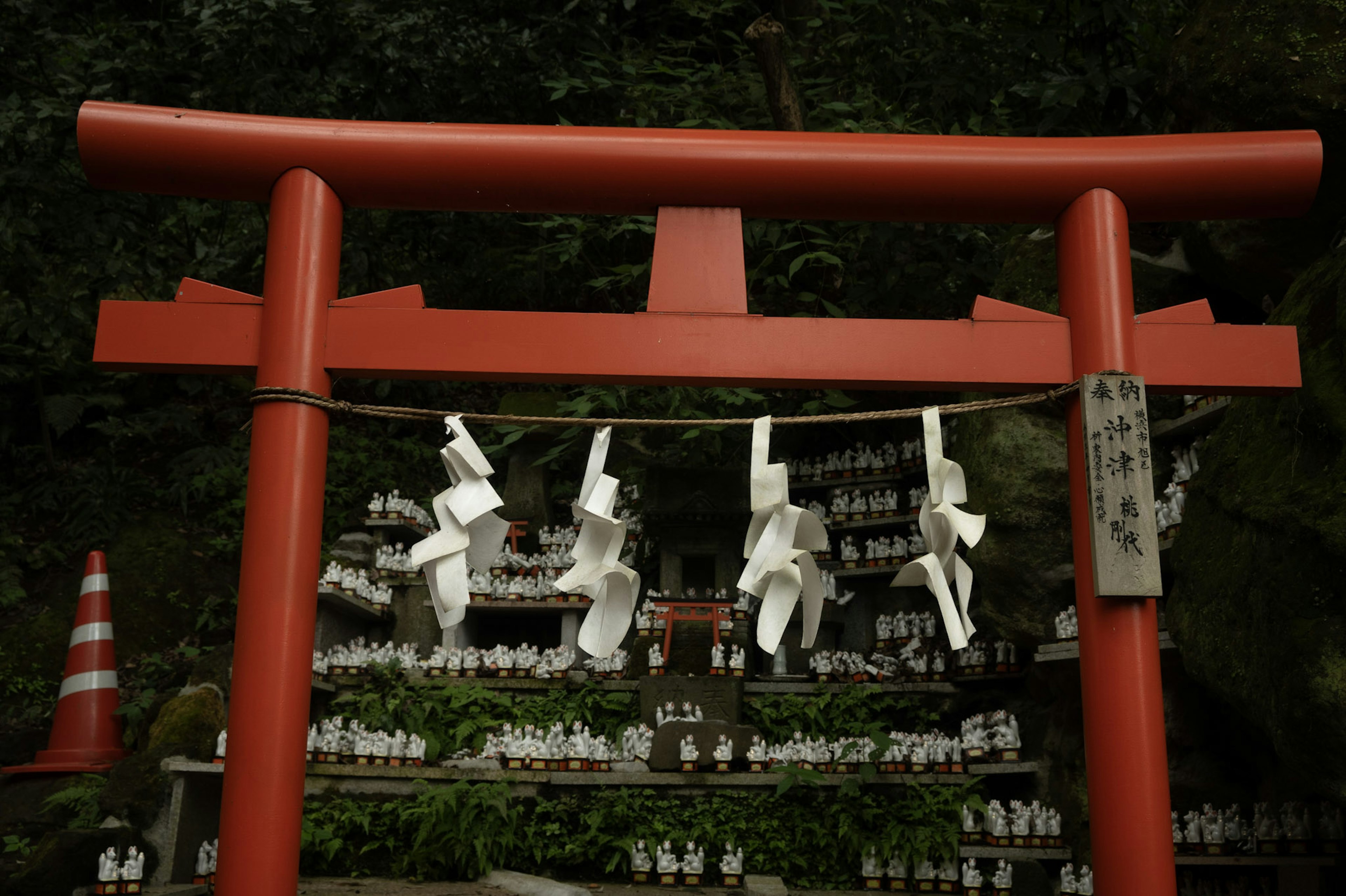 Puerta torii roja con omikuji blancos colgados