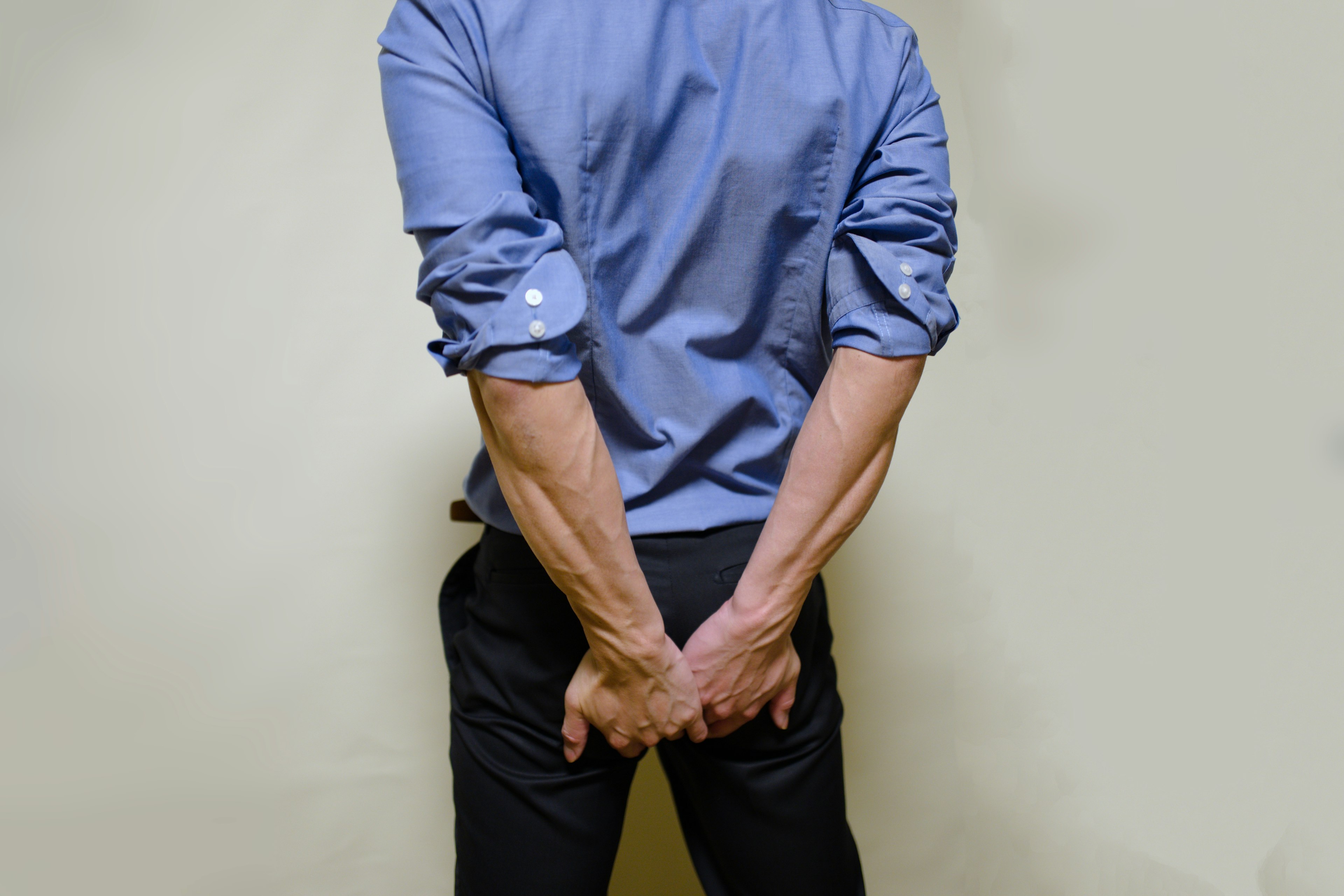 A man in a blue shirt standing with his back turned