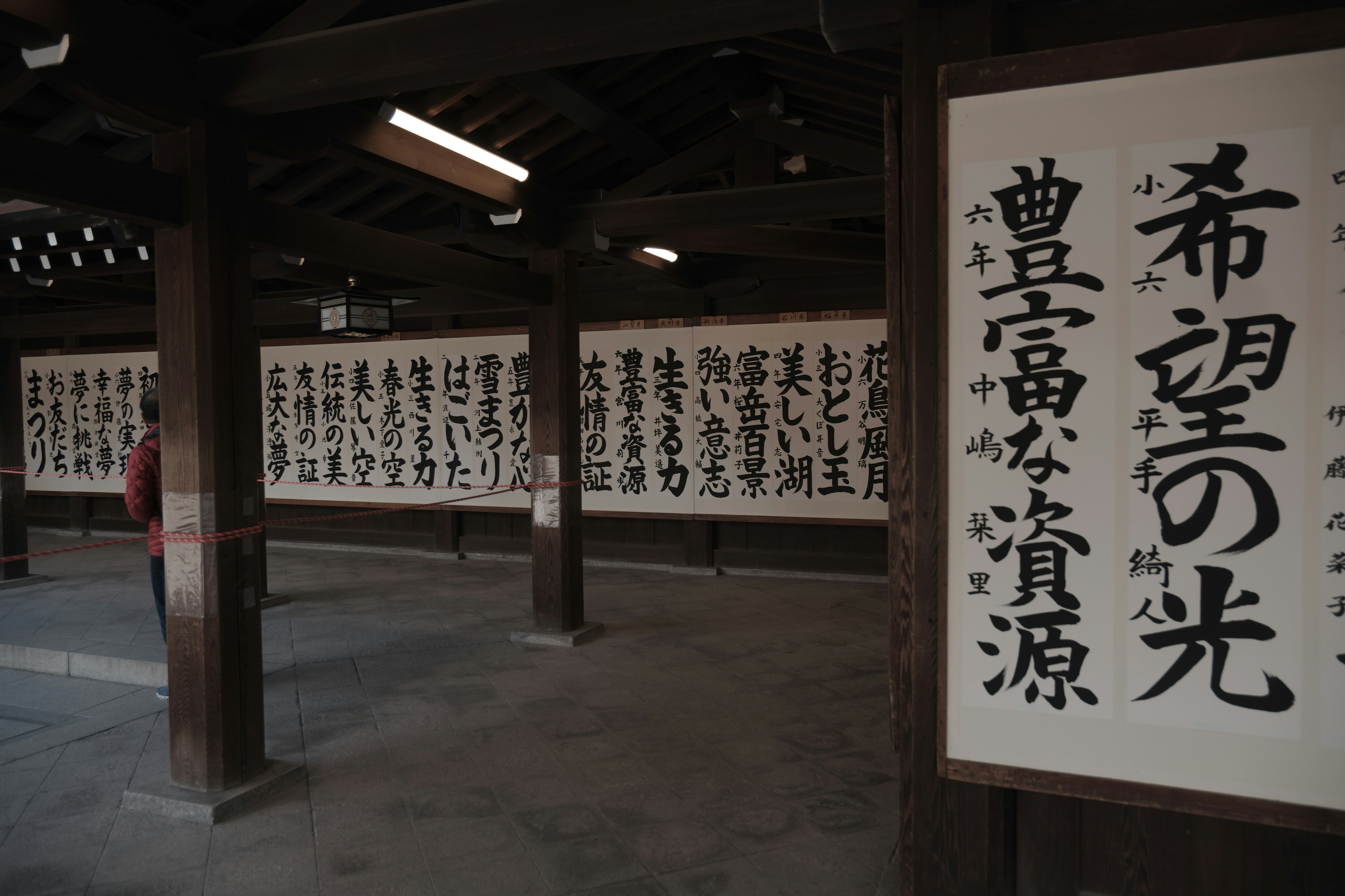 Texto caligráfico japonés exhibido en paneles de madera en un entorno tradicional