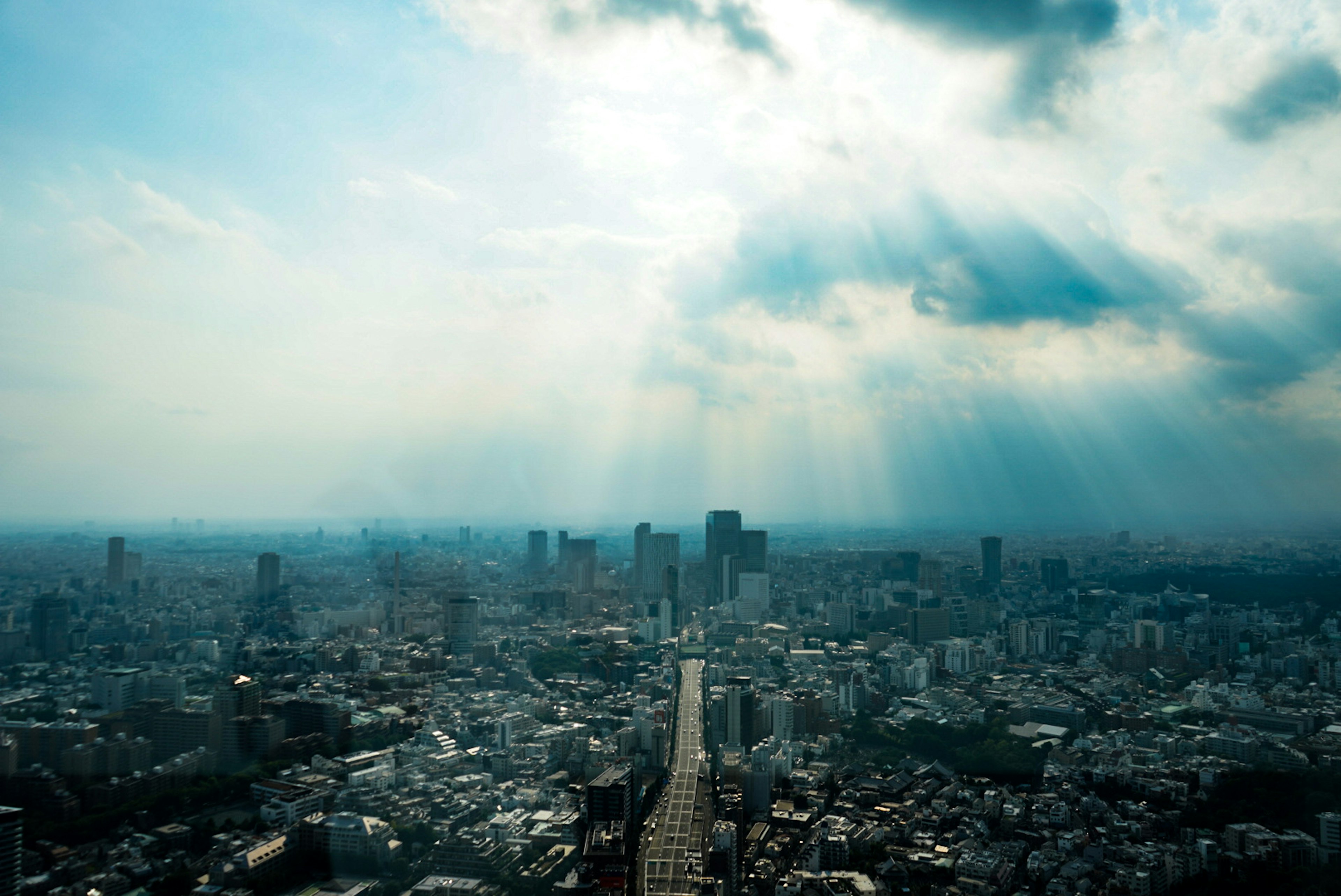 都市の眺望と雲の中の光のビーム