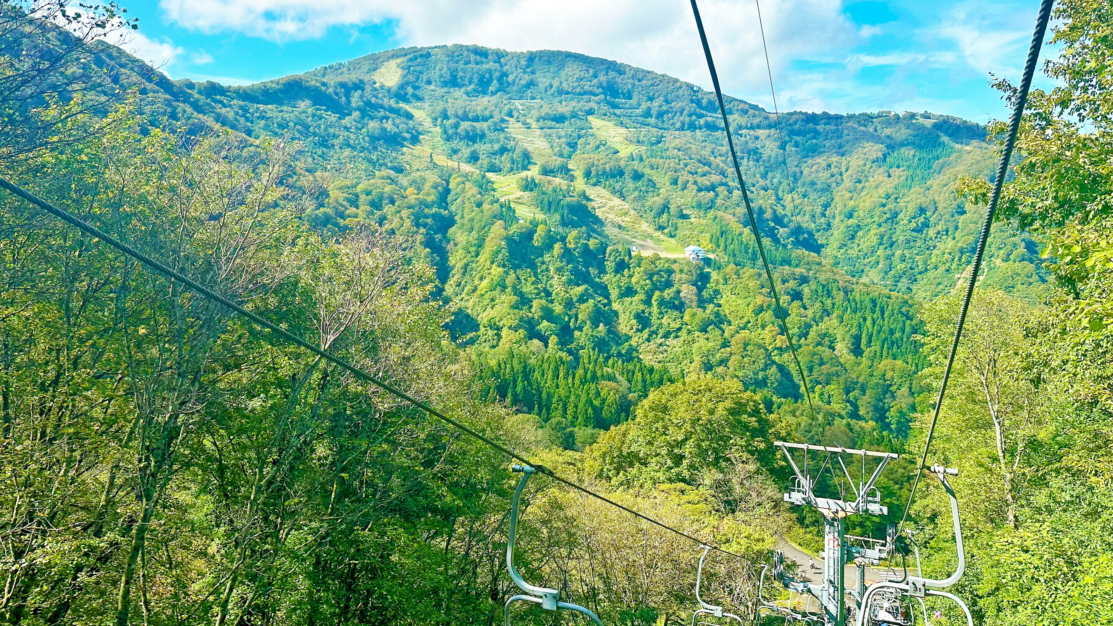 从滑椅上看到的郁郁葱葱的绿色山脉和蓝天