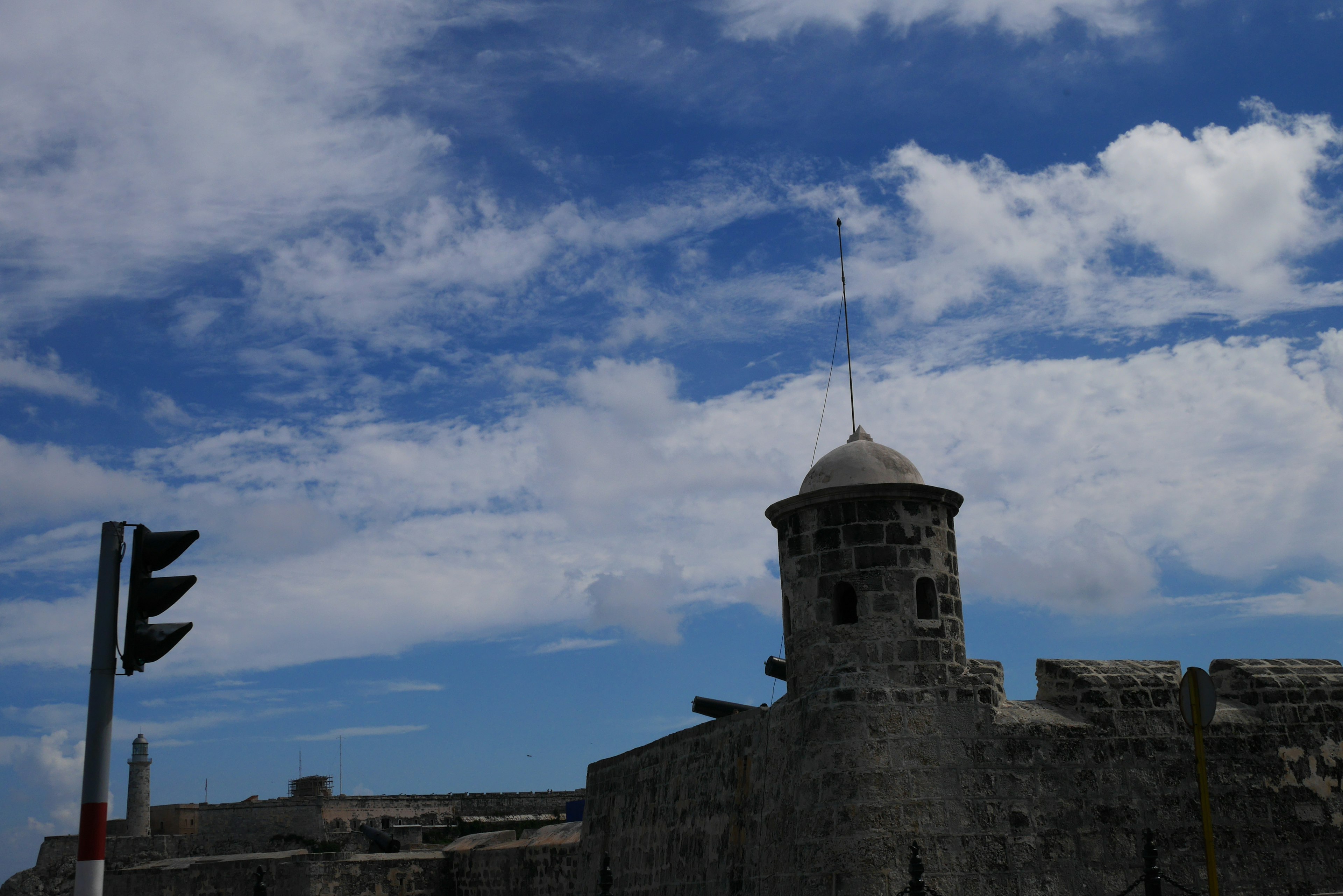 Tour en pierre historique et mur sous un ciel bleu avec des nuages