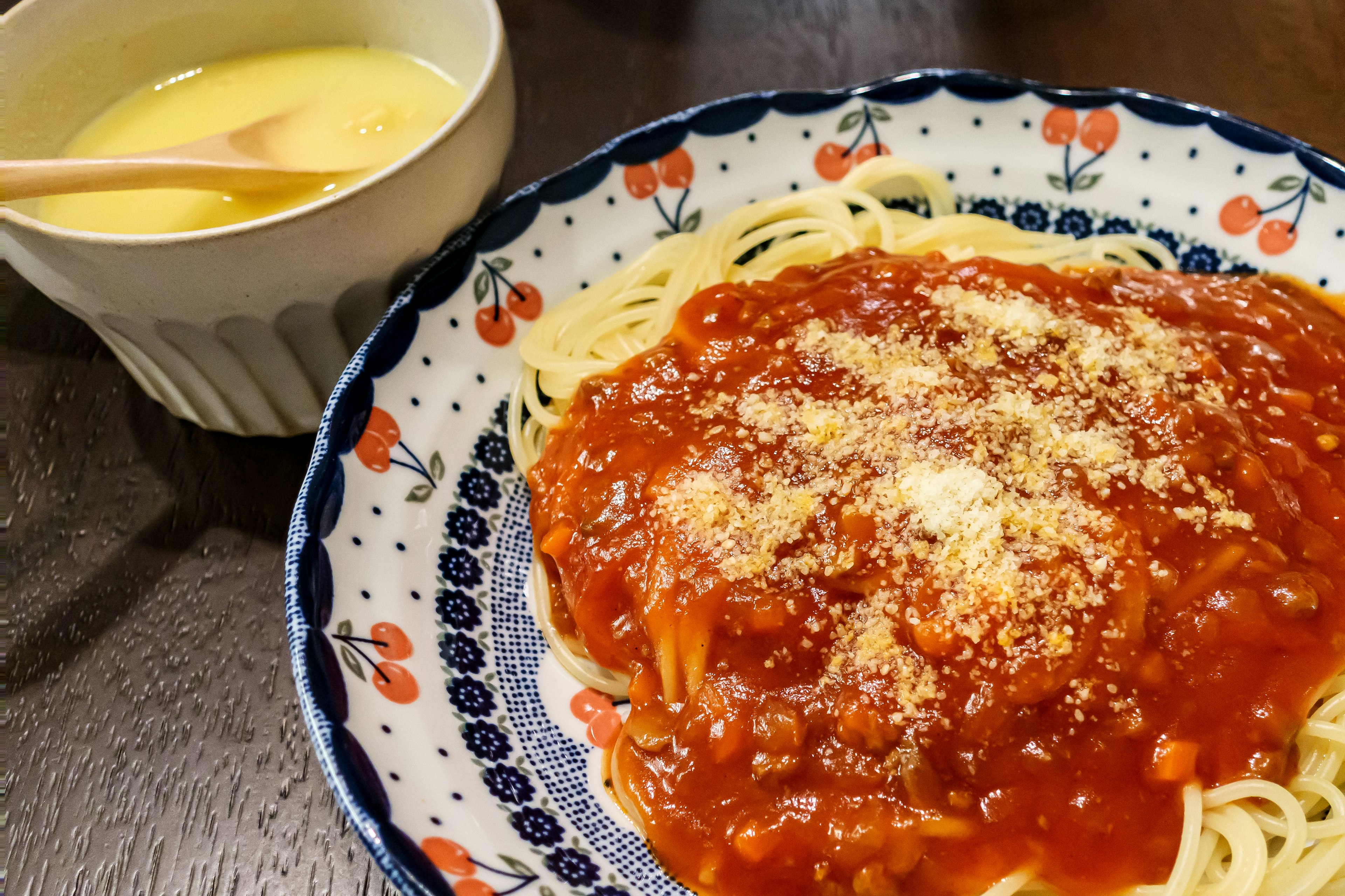 Assiette de spaghetti avec sauce tomate et un bol de dessert crémeux