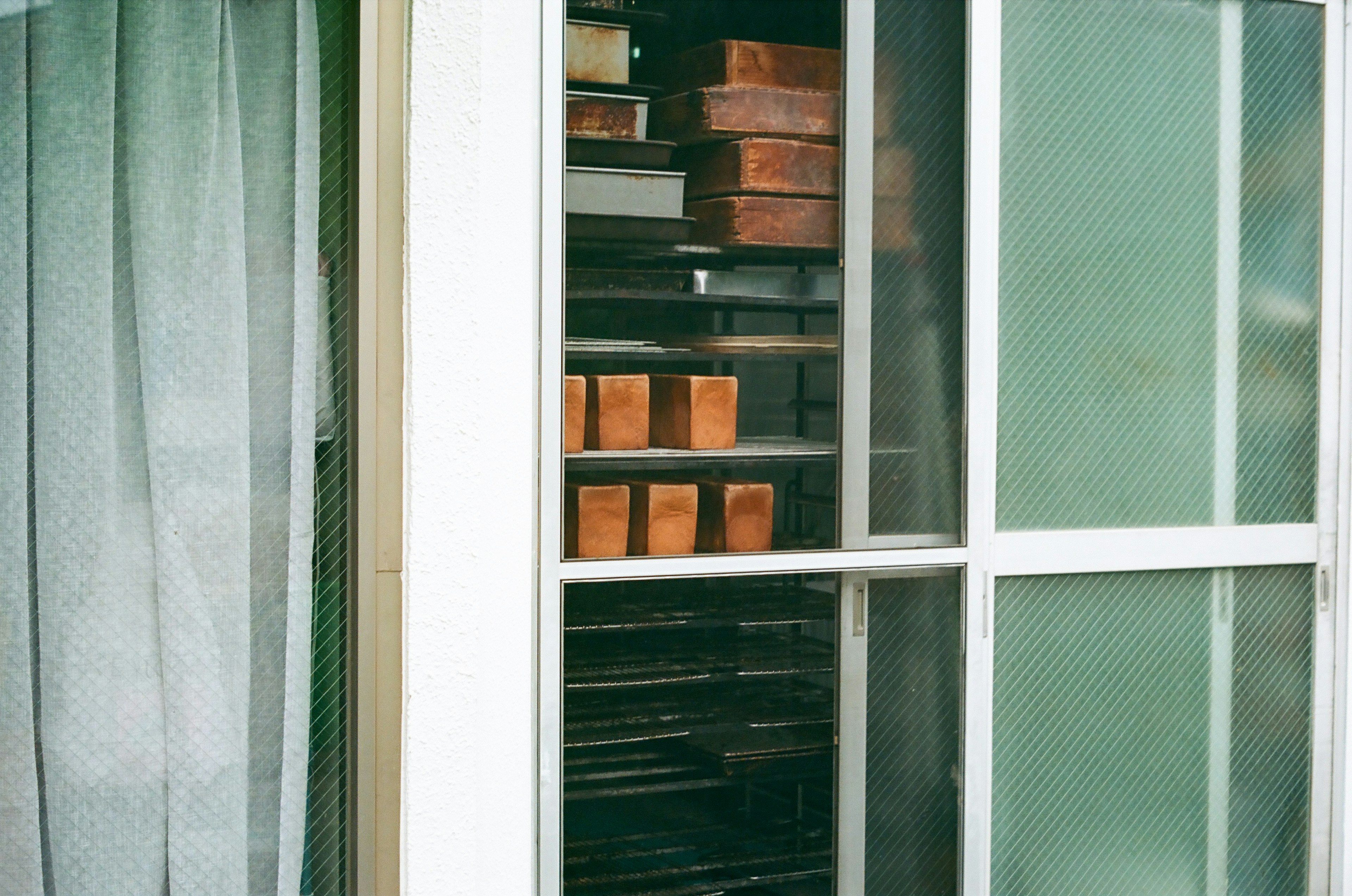 View through a window showing wooden boxes and shelves