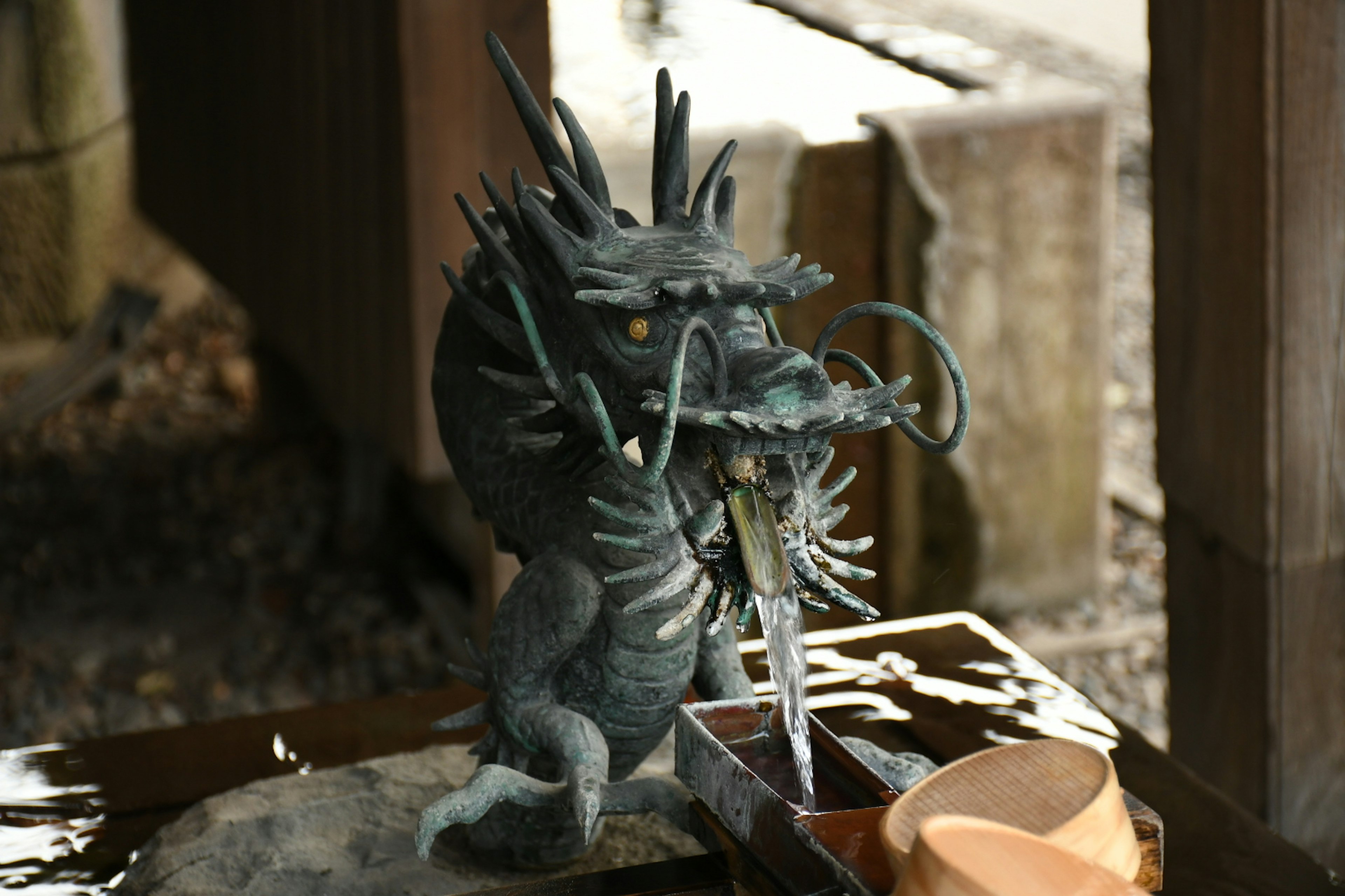 Sculpture d'un dragon crachant de l'eau dans un sanctuaire japonais