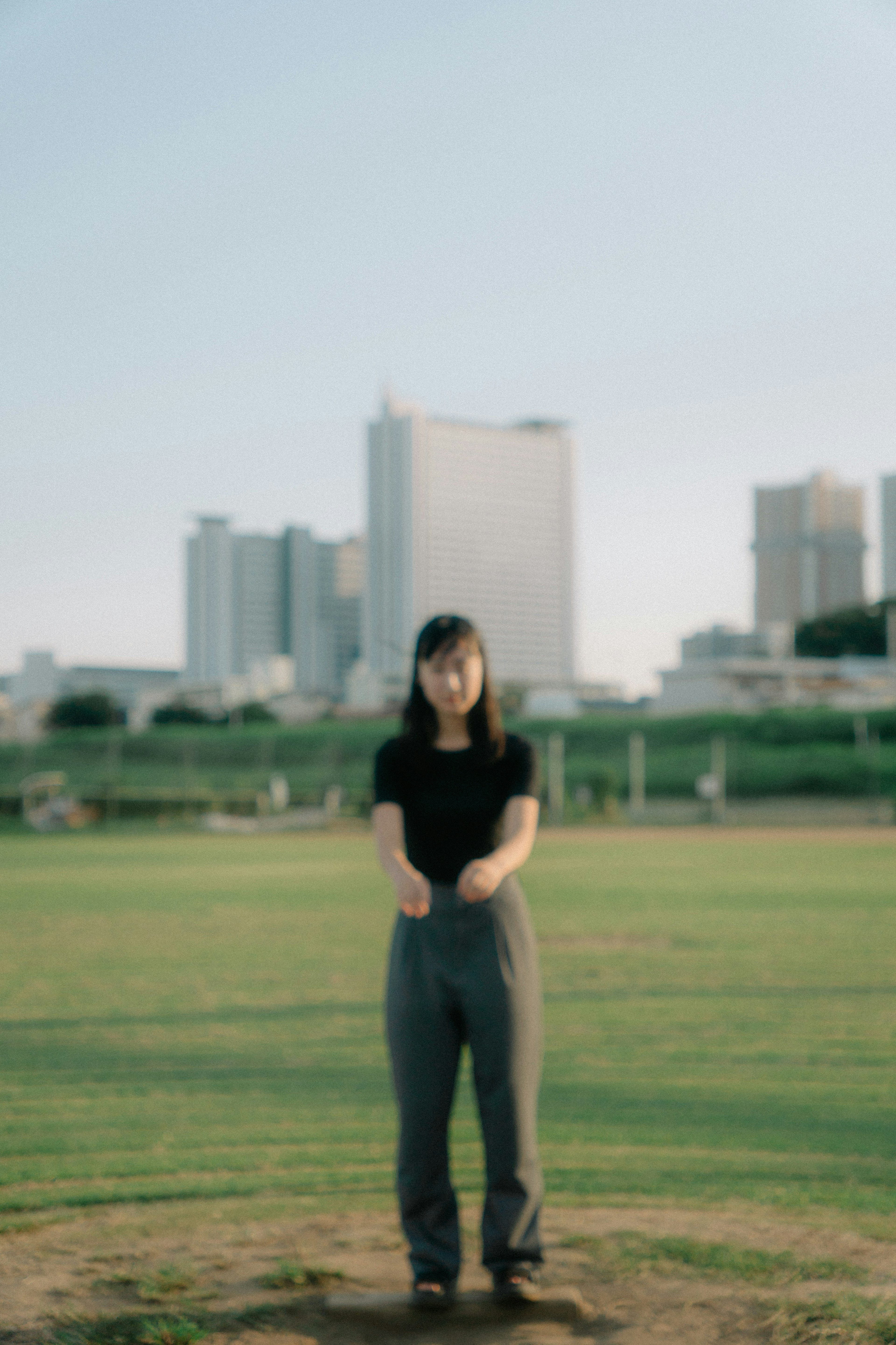 公園で立っている女性の姿と高層ビルの背景