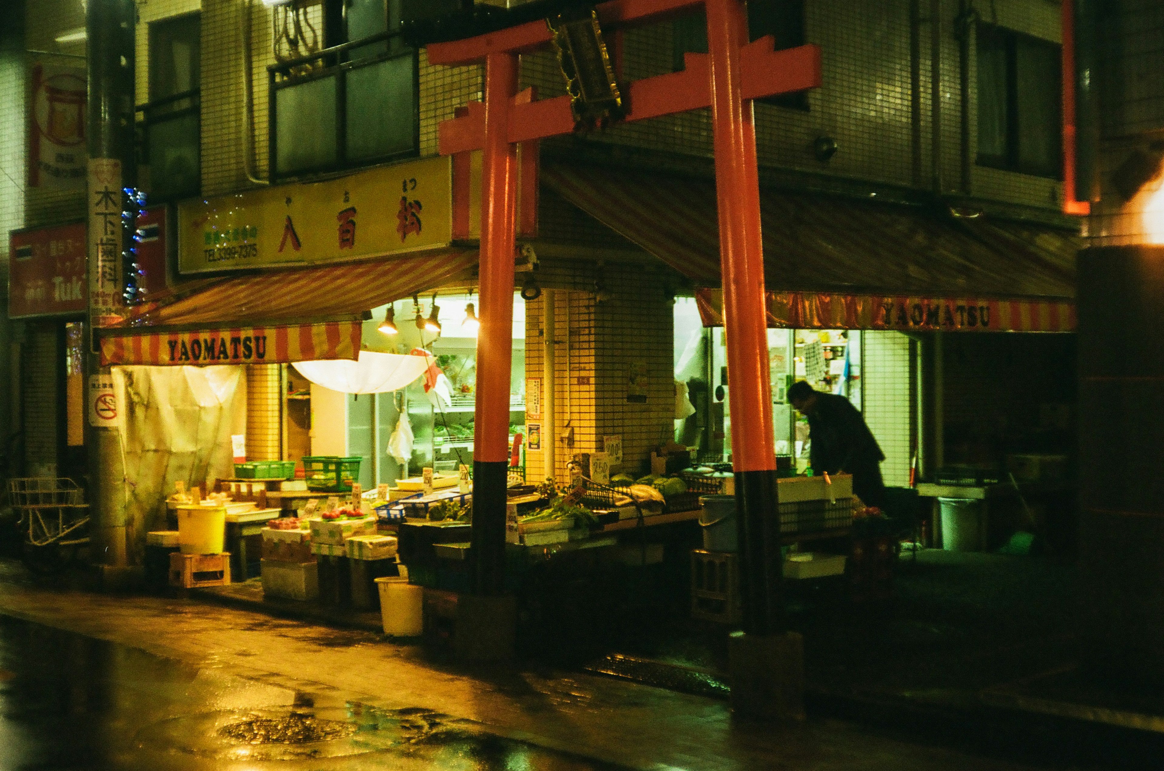 Cảnh chợ đêm với cổng torii đỏ