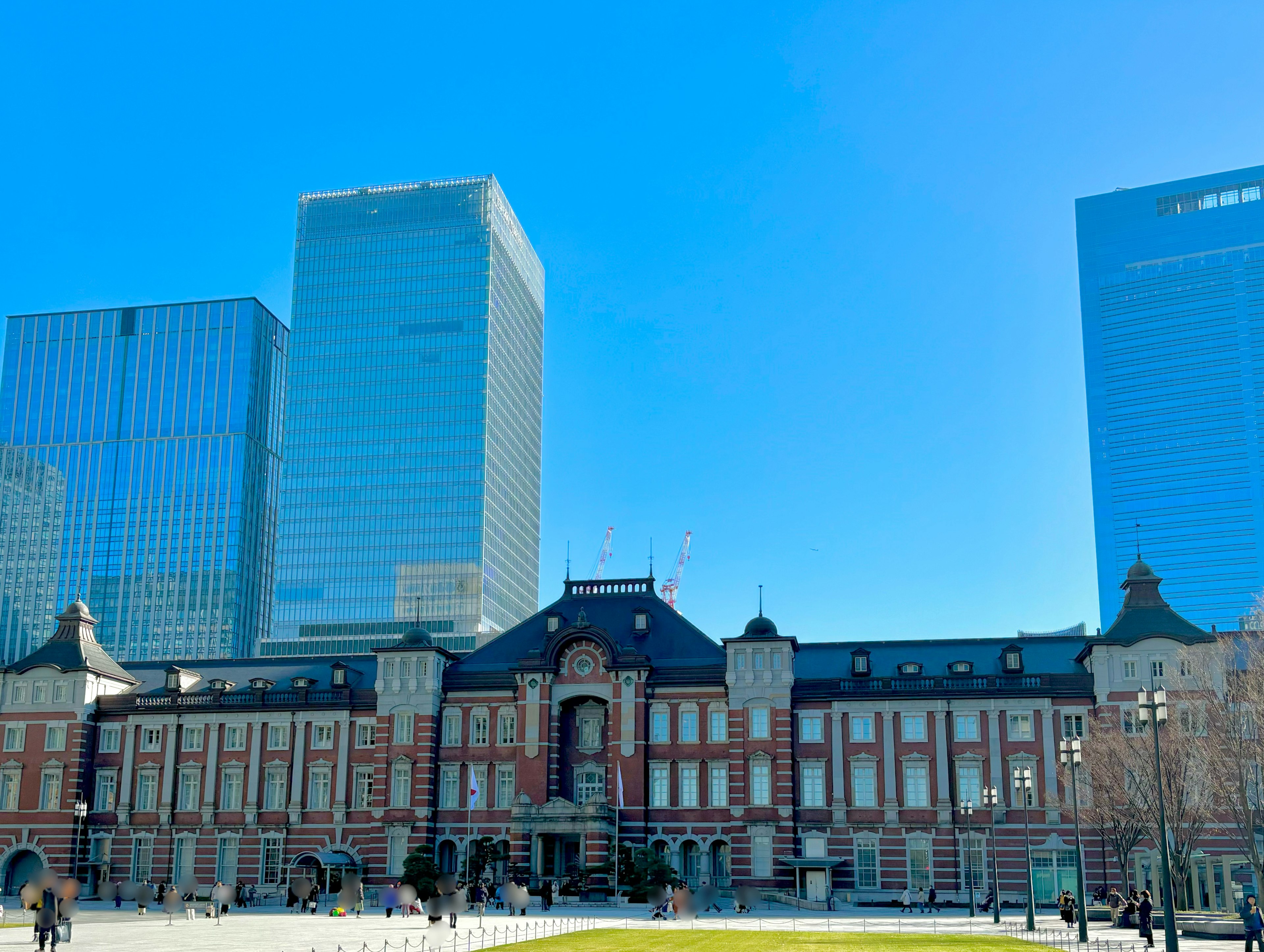 Historic Tokyo Station building with modern skyscrapers in the background