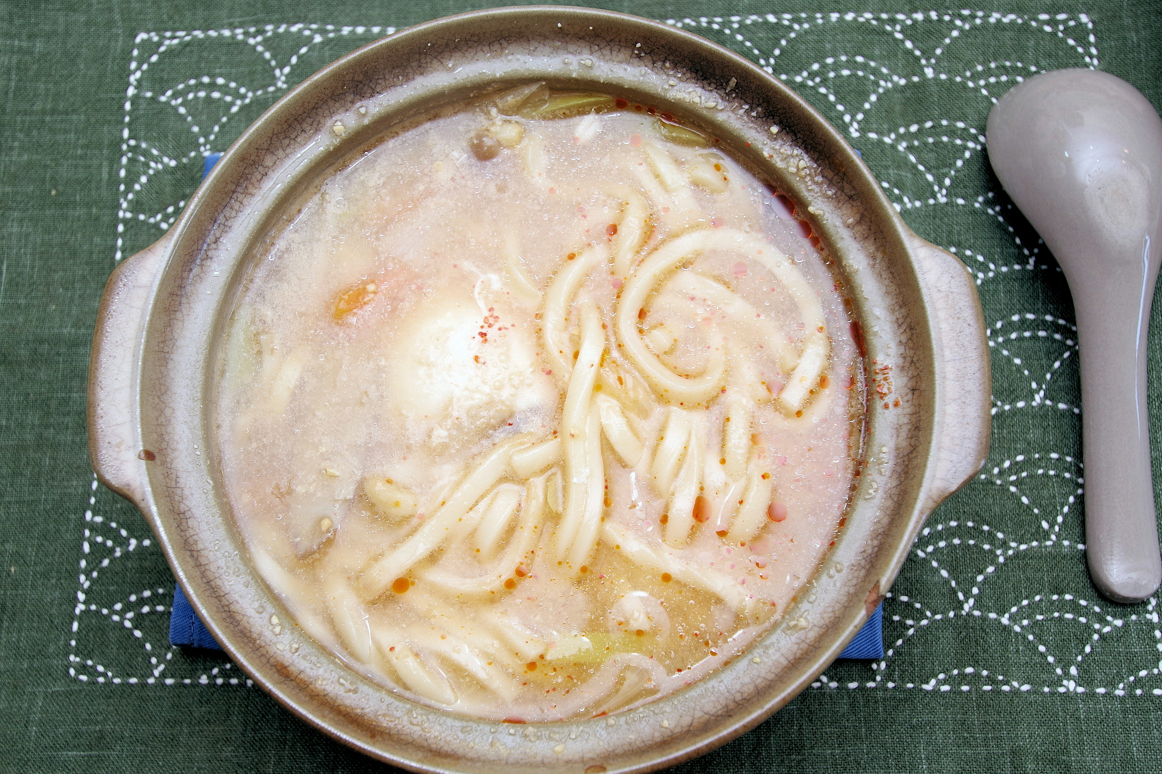 A pot of udon noodles in broth