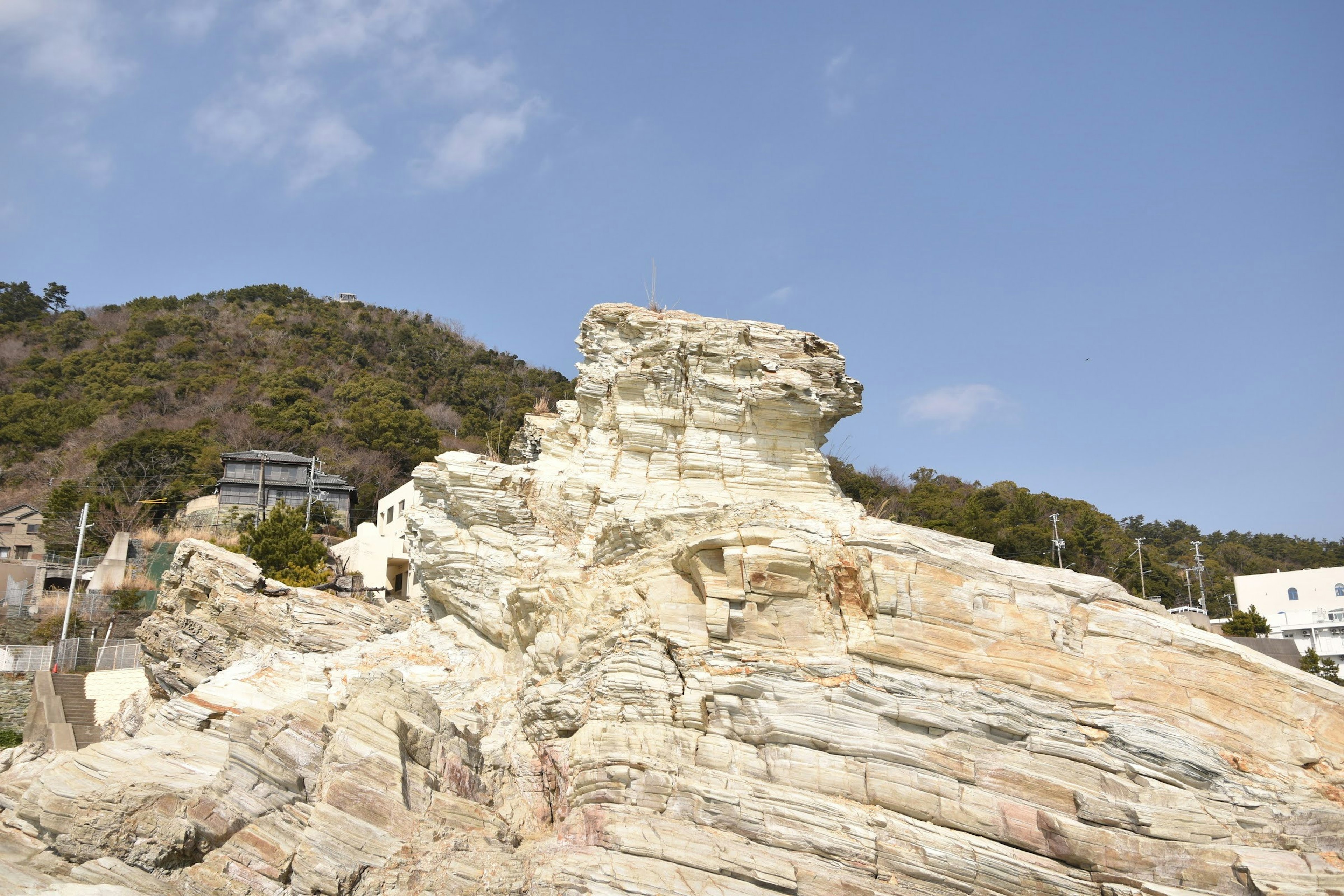 Coastal scene featuring white rock formations and blue sky