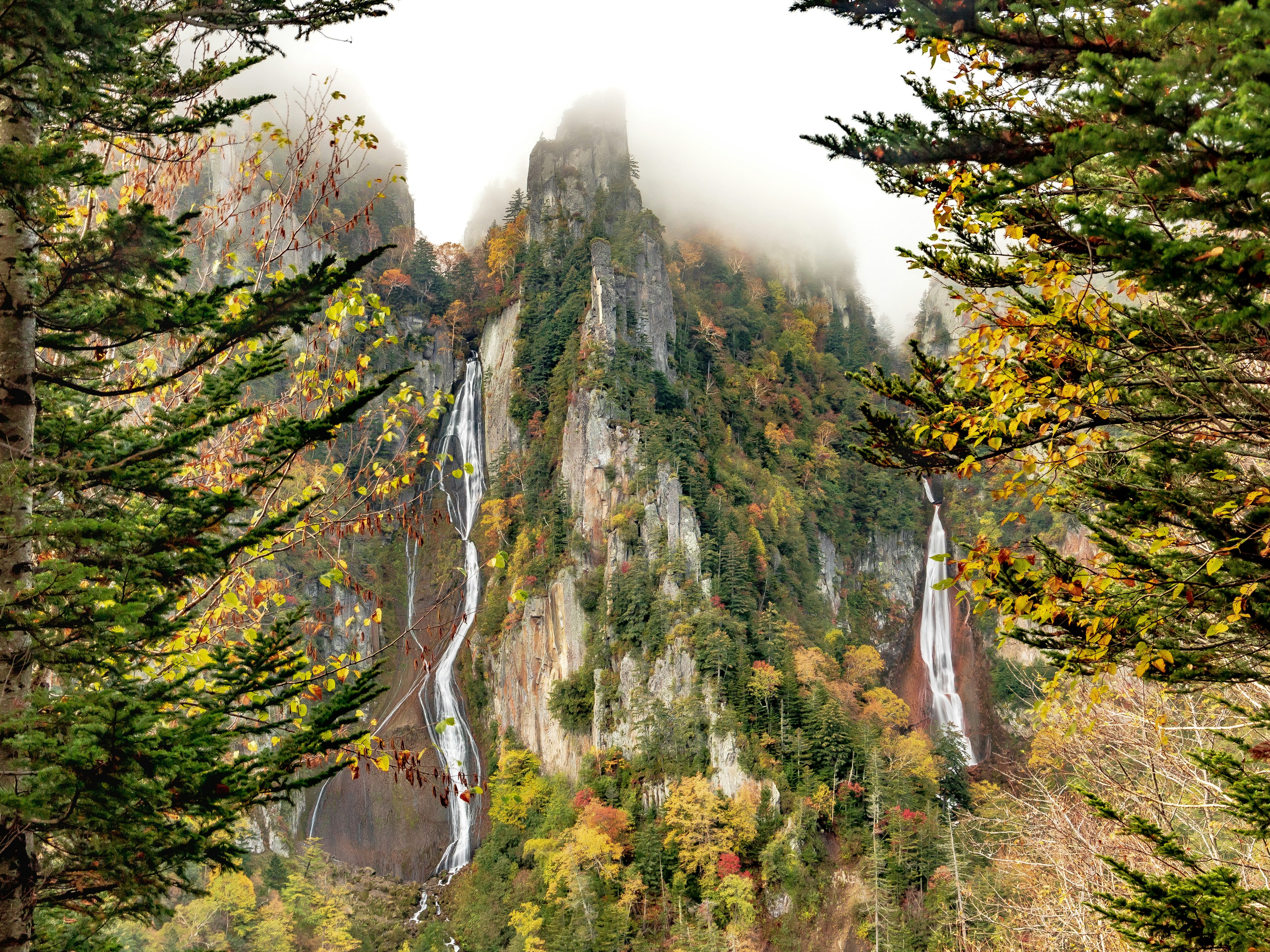 Vista panoramica di fogliame autunnale con cascate e montagne