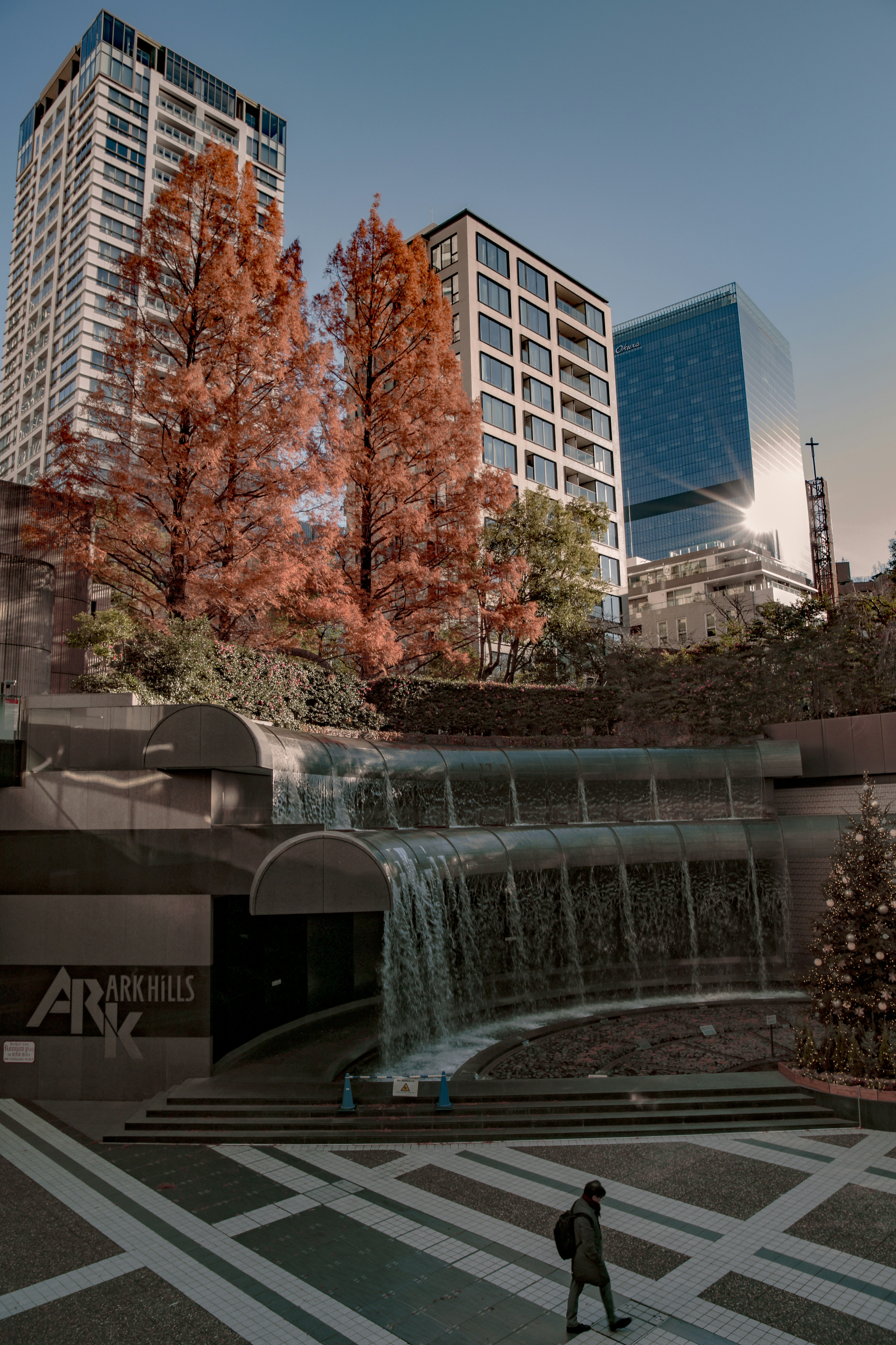 Paisaje urbano con árboles de otoño y una cascada