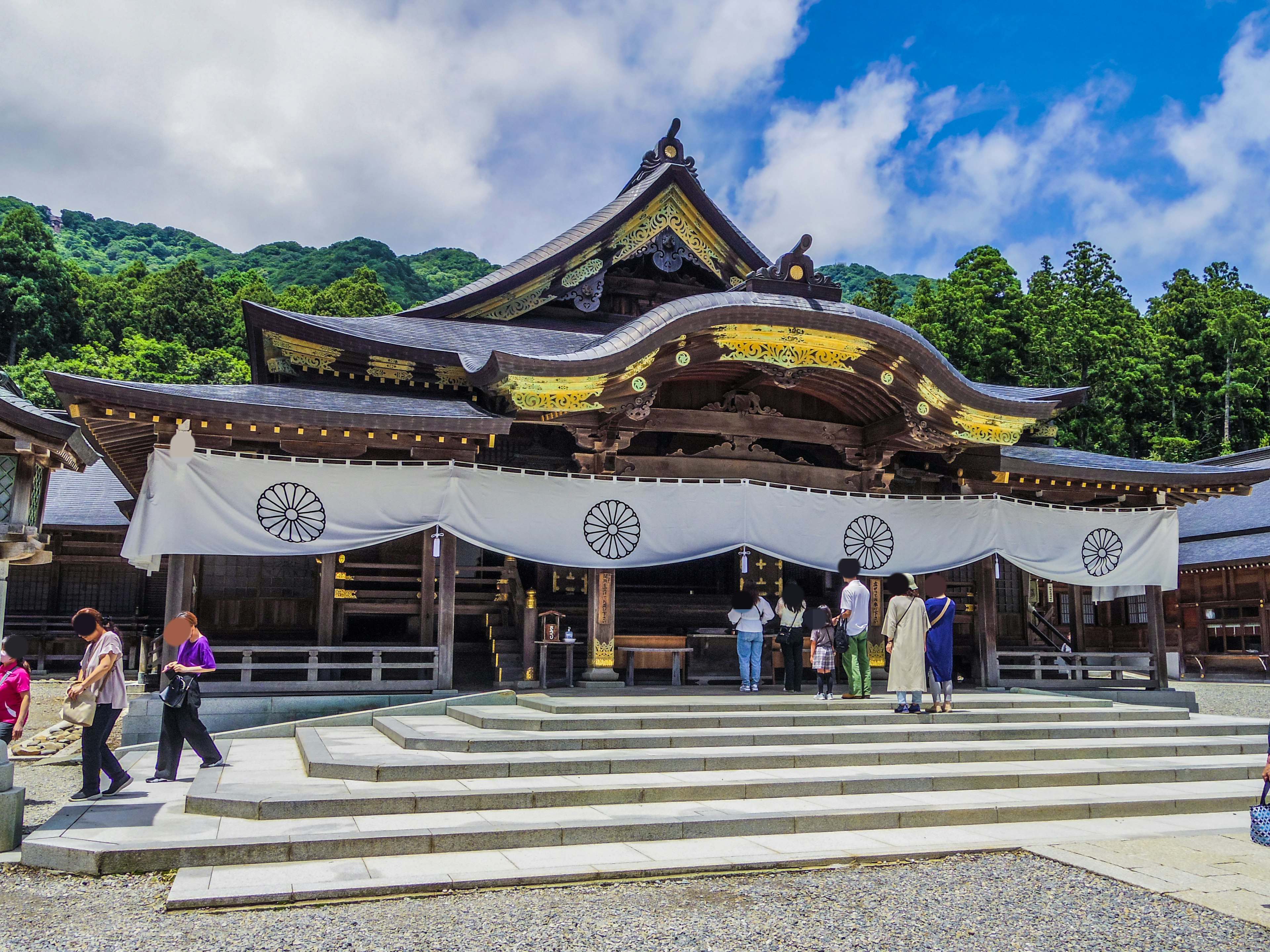 A beautiful shrine building under a blue sky with many visitors