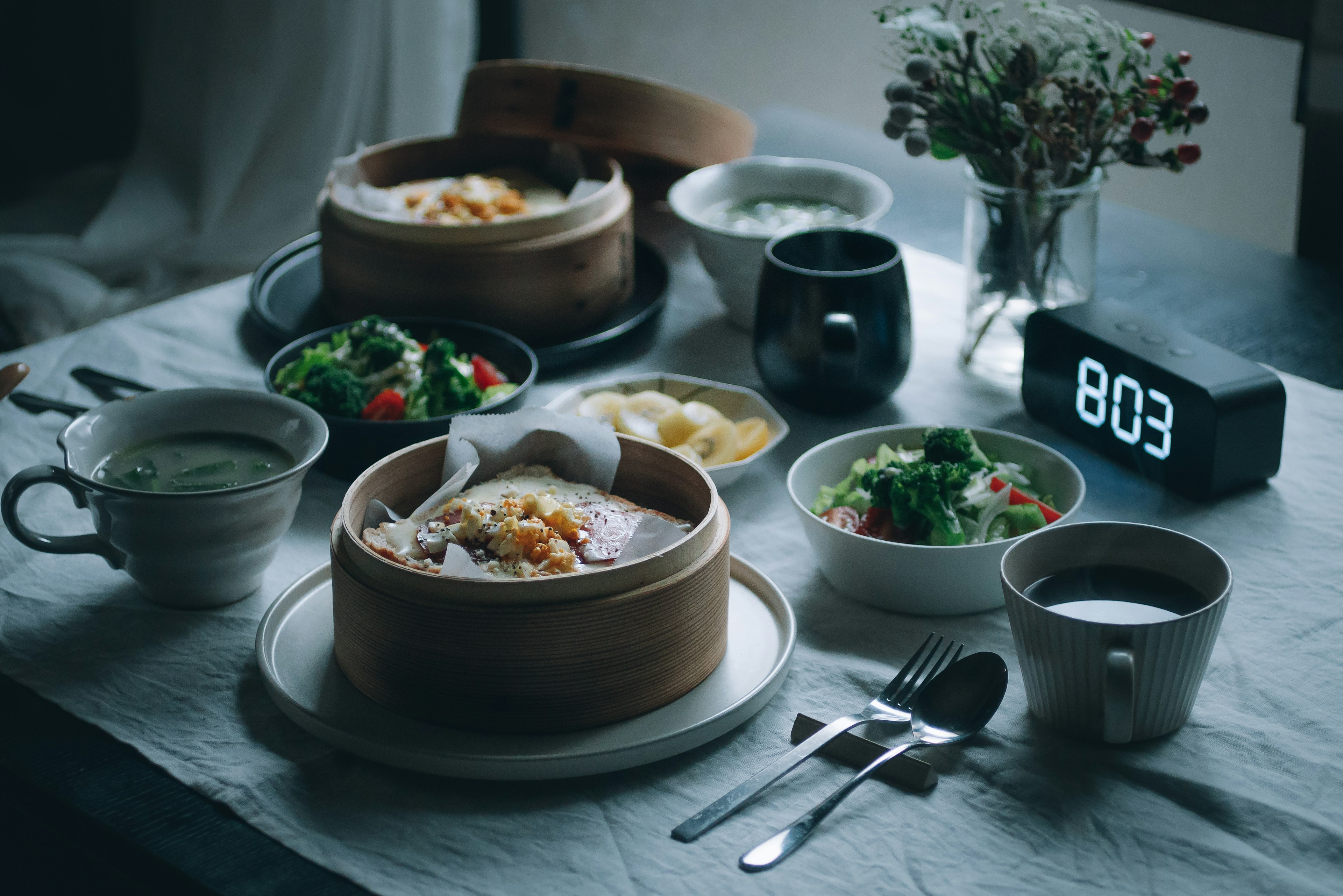 Una mesa de desayuno con platos al vapor y ensaladas