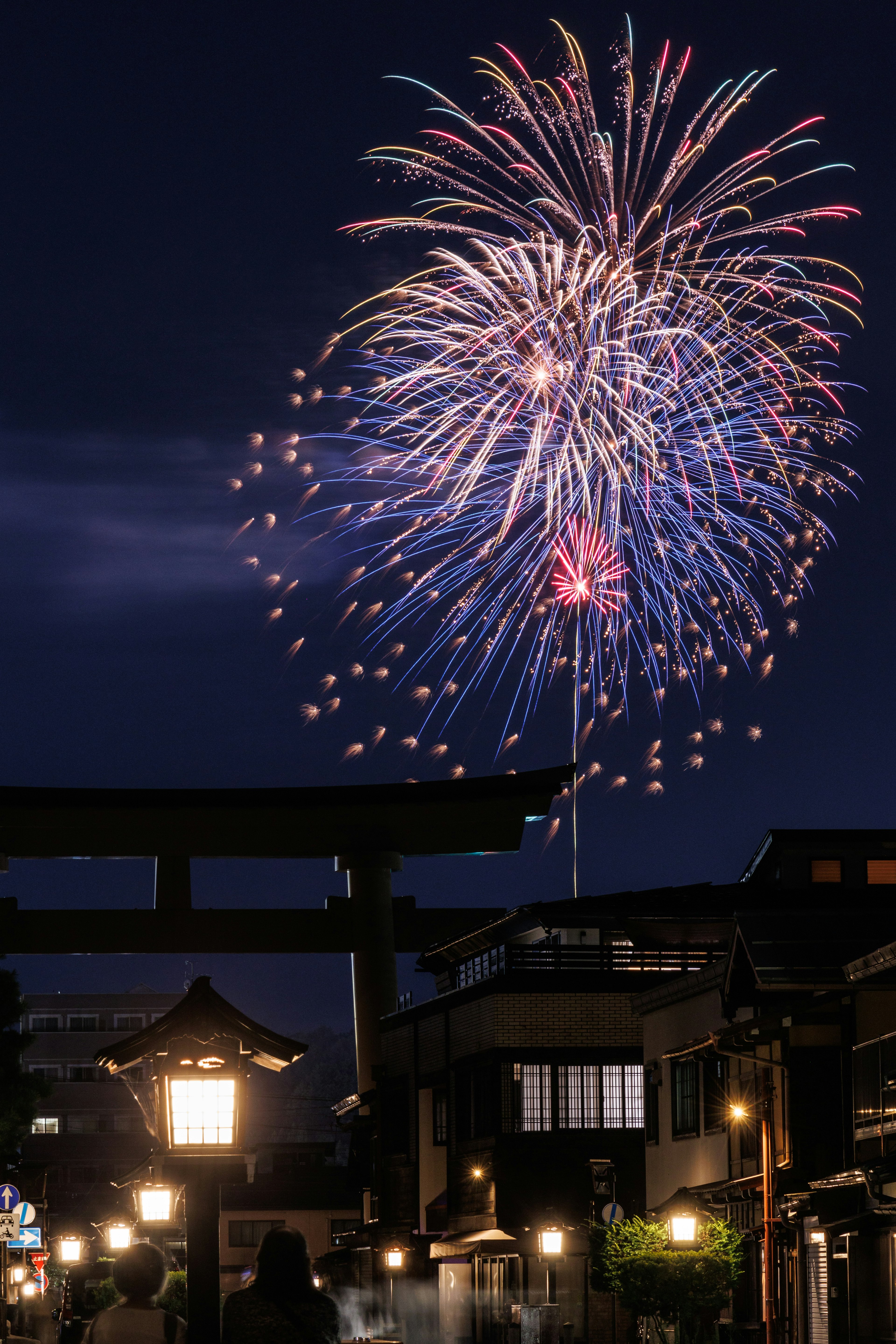 夜空中綻放的彩色煙火在傳統建築上方