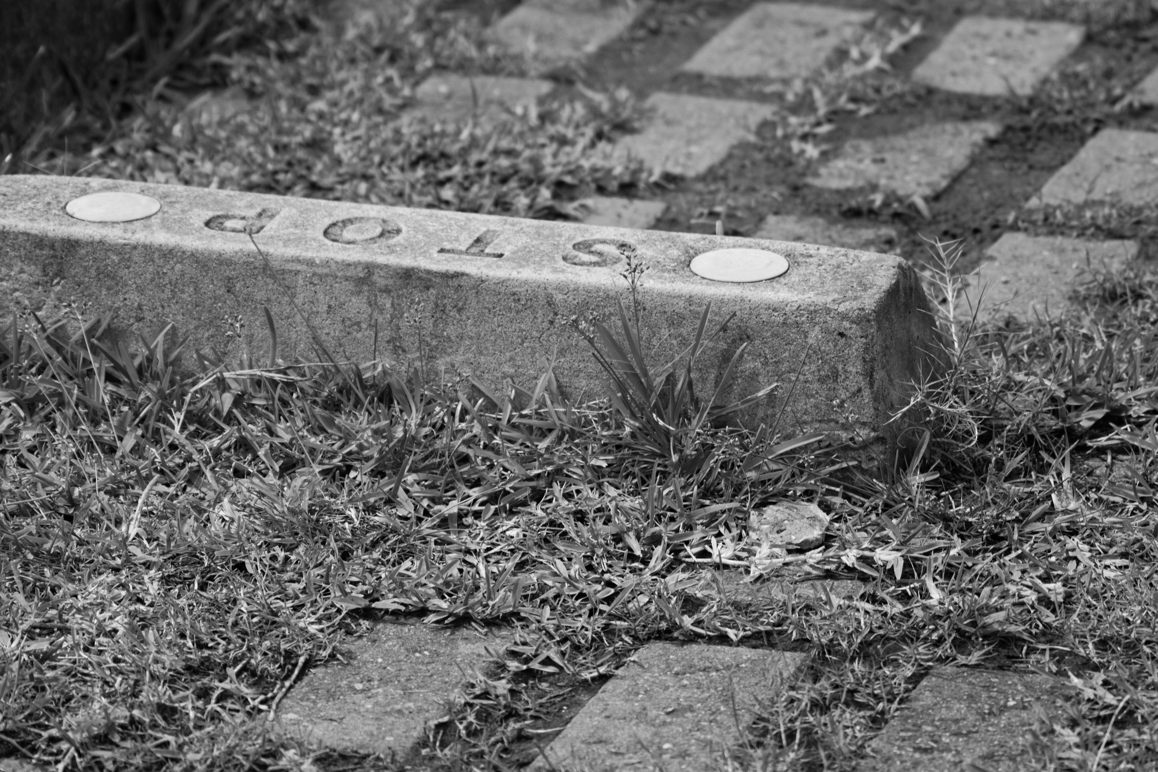 A fallen stone block on the path with the word 'STOP' engraved