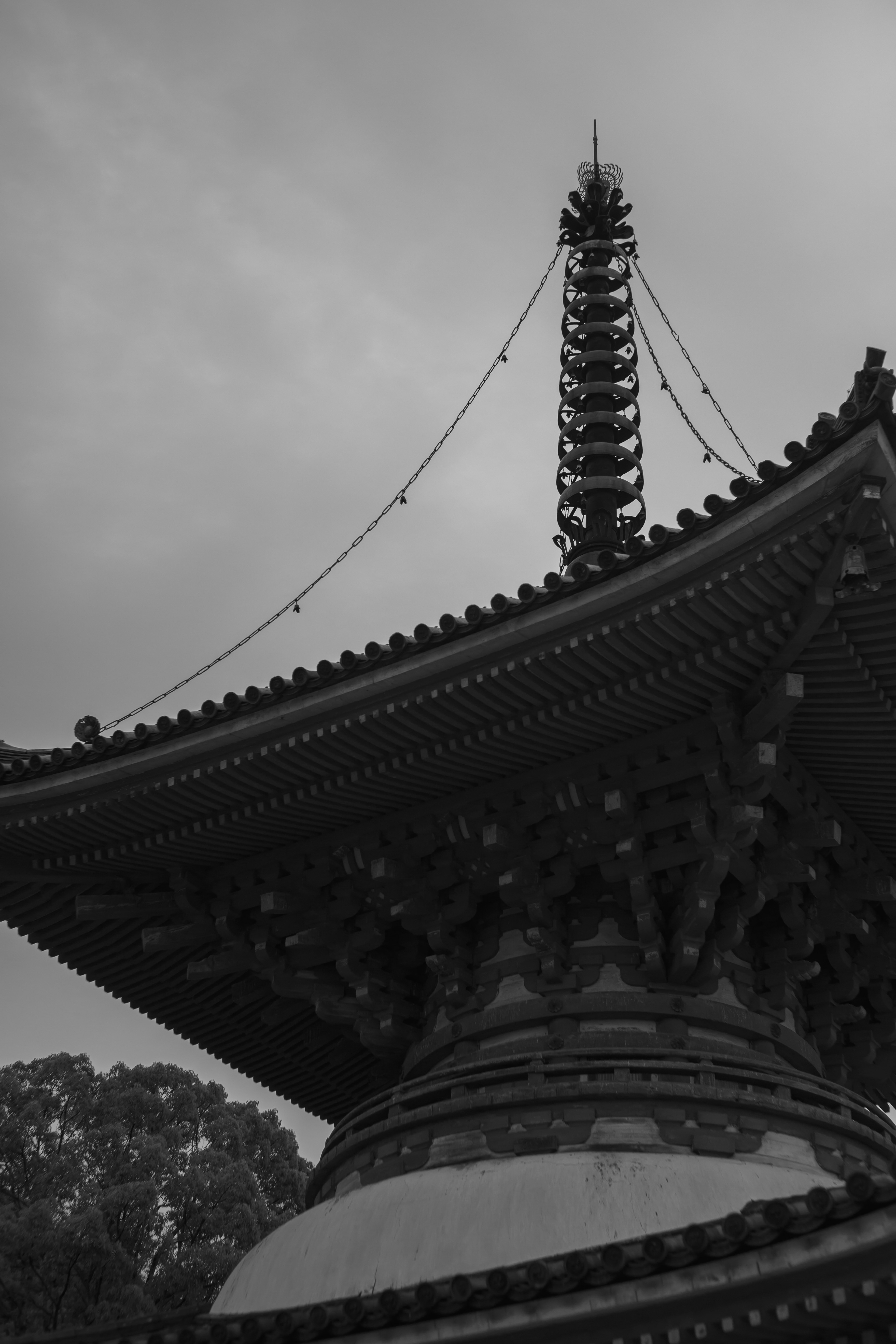 Foto en blanco y negro de la sección superior de una pagoda japonesa tradicional