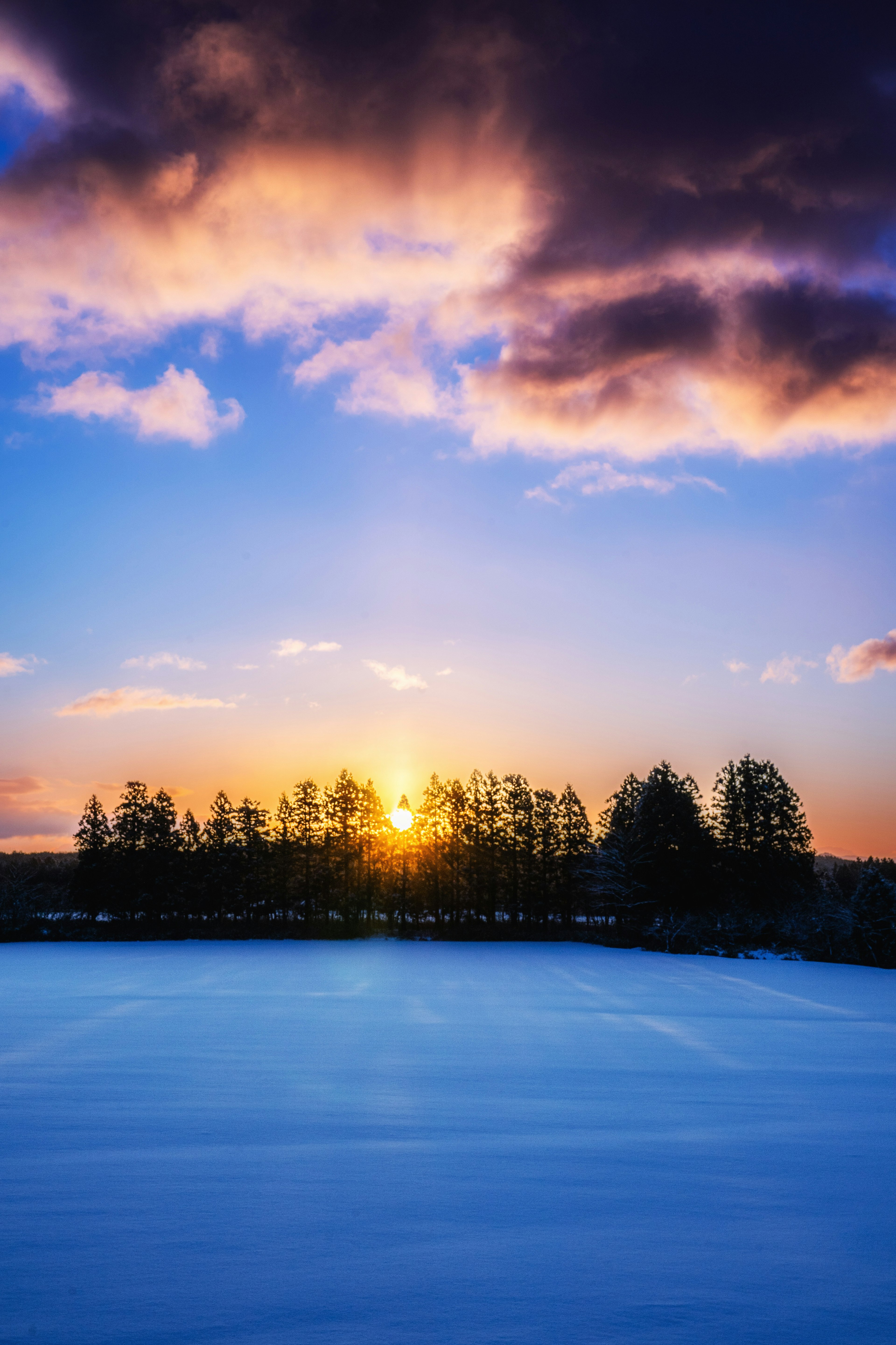 Sunset over a snowy landscape with colorful clouds