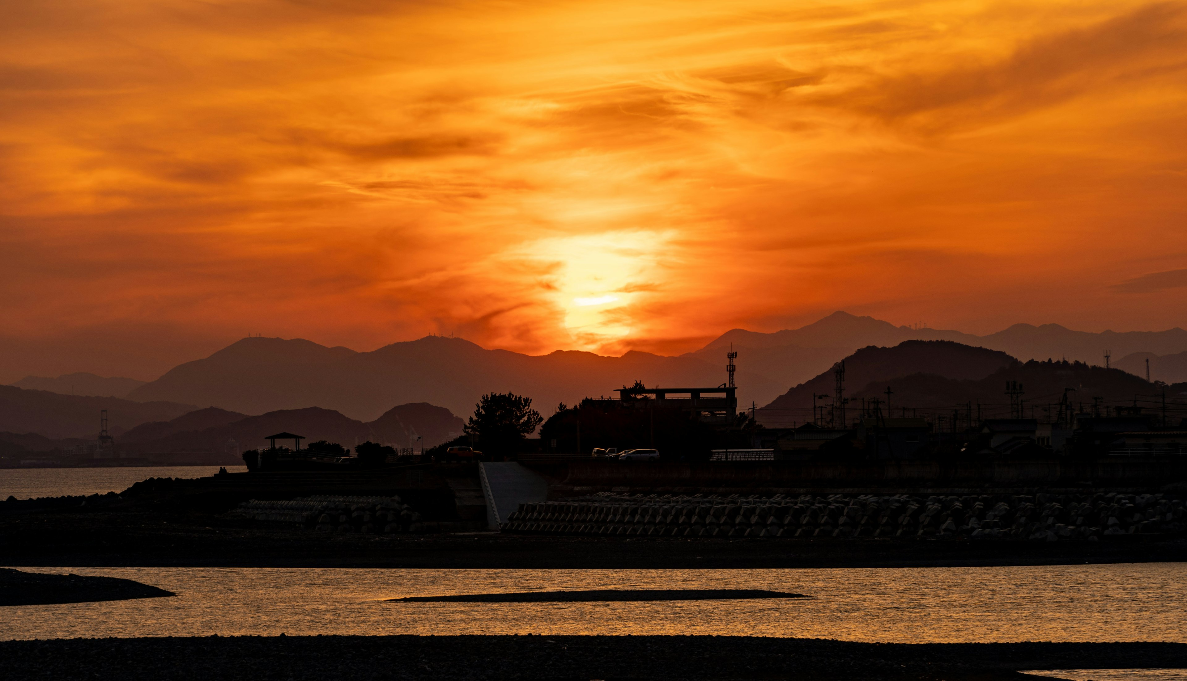 Magnifique paysage de coucher de soleil avec des montagnes en arrière-plan et une mer sereine