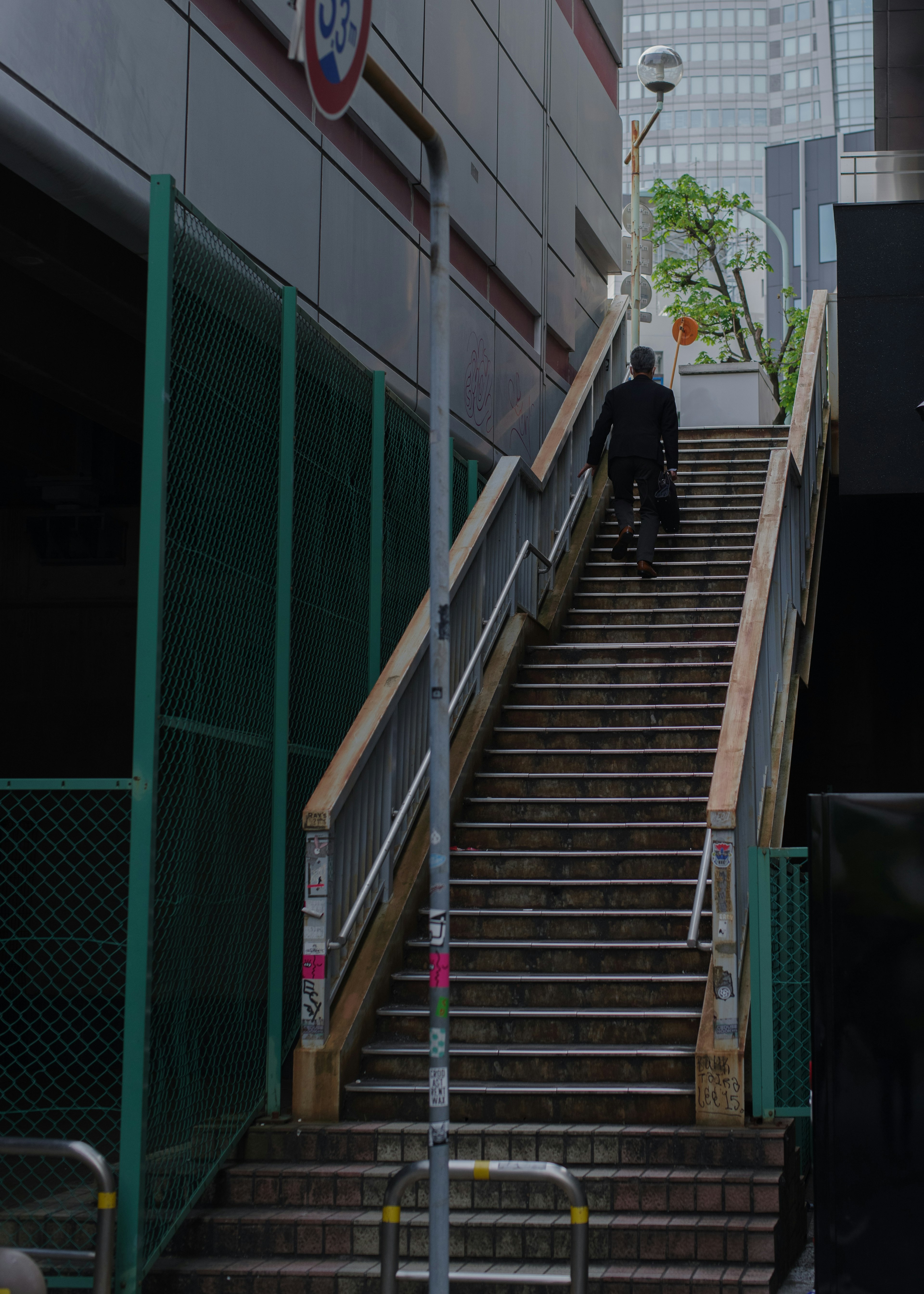 A man walking up a staircase with surrounding buildings