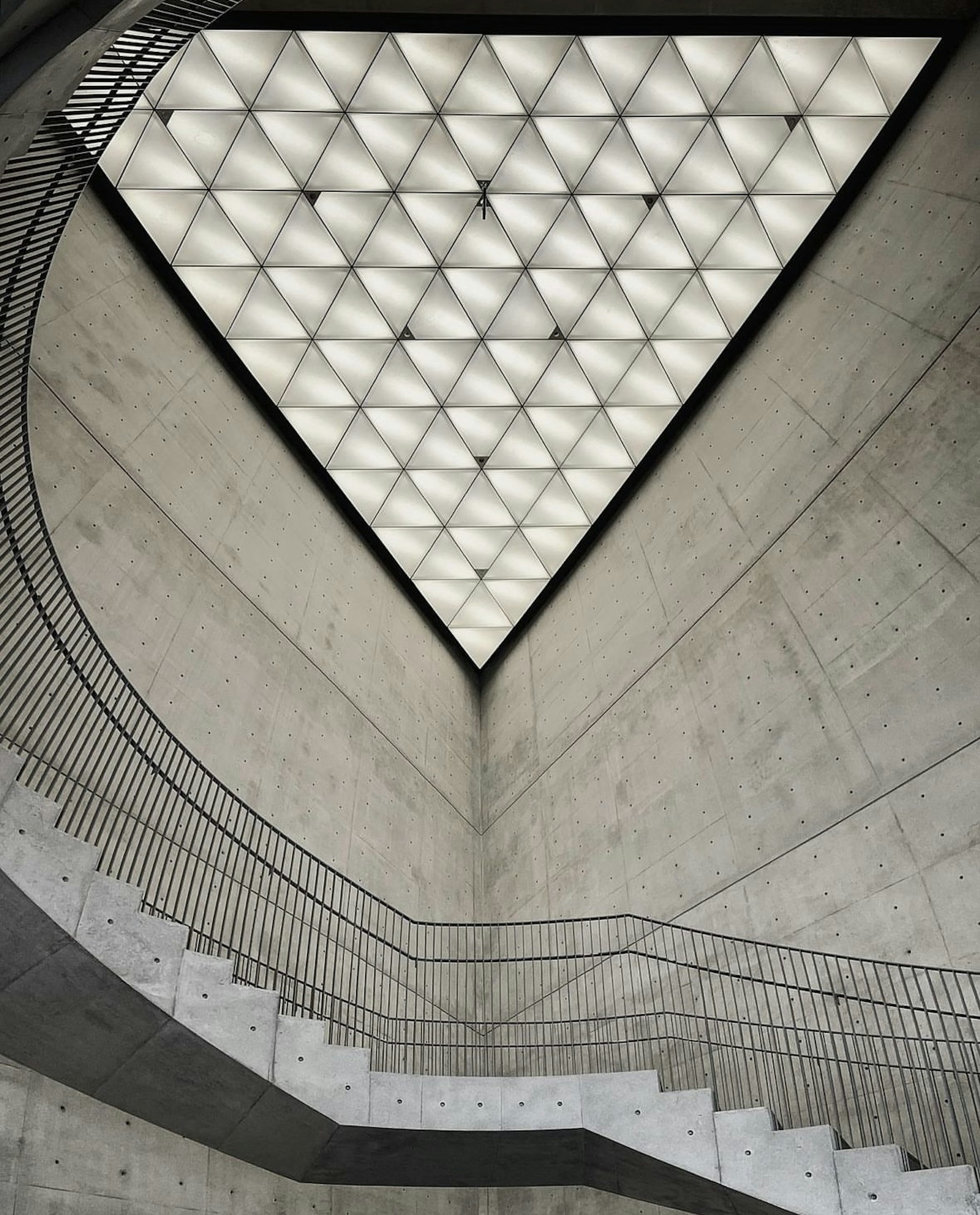 Interior space featuring a triangular ceiling and curved staircase