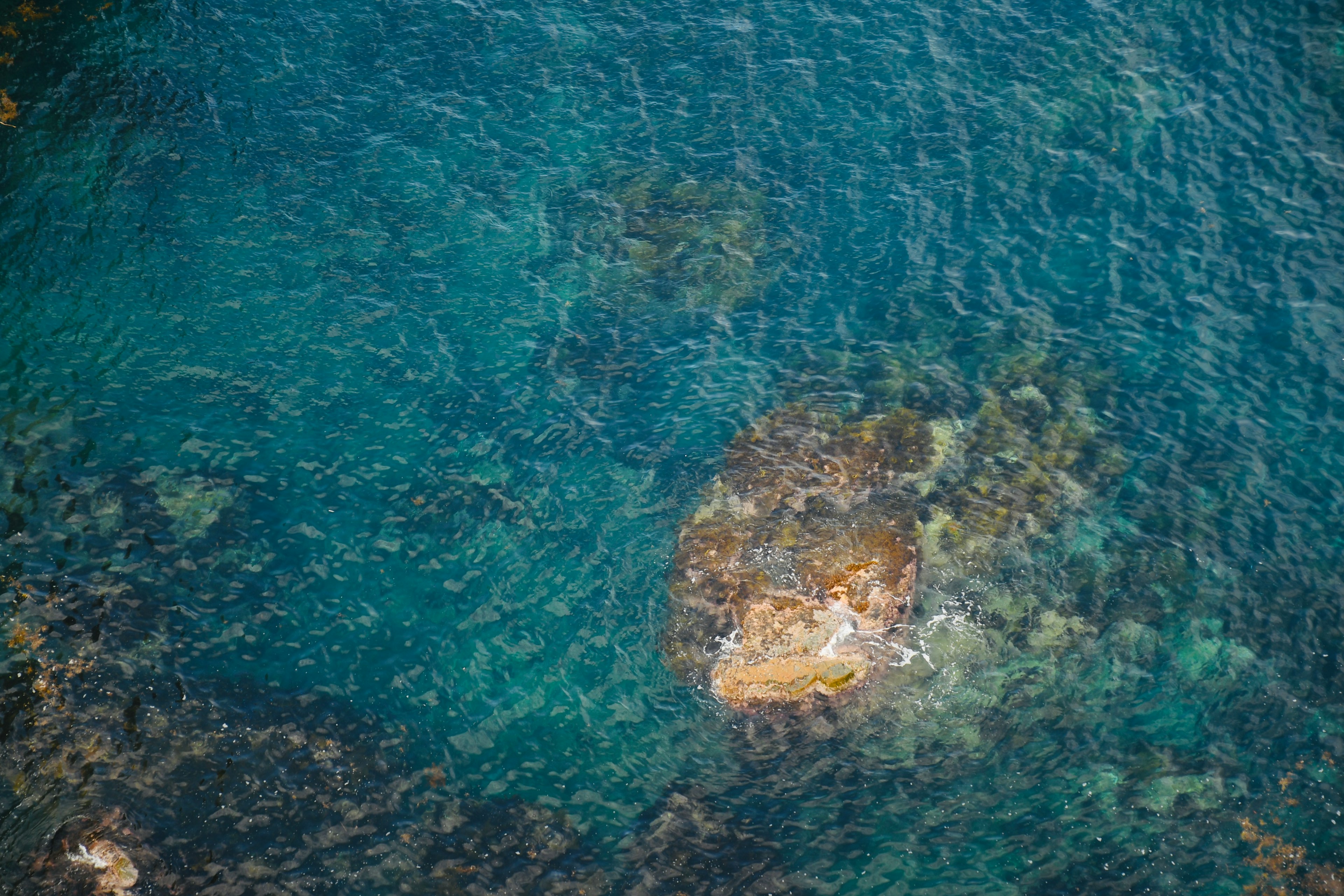 Blick auf klares blaues Wasser mit sichtbaren Felsen unter der Oberfläche