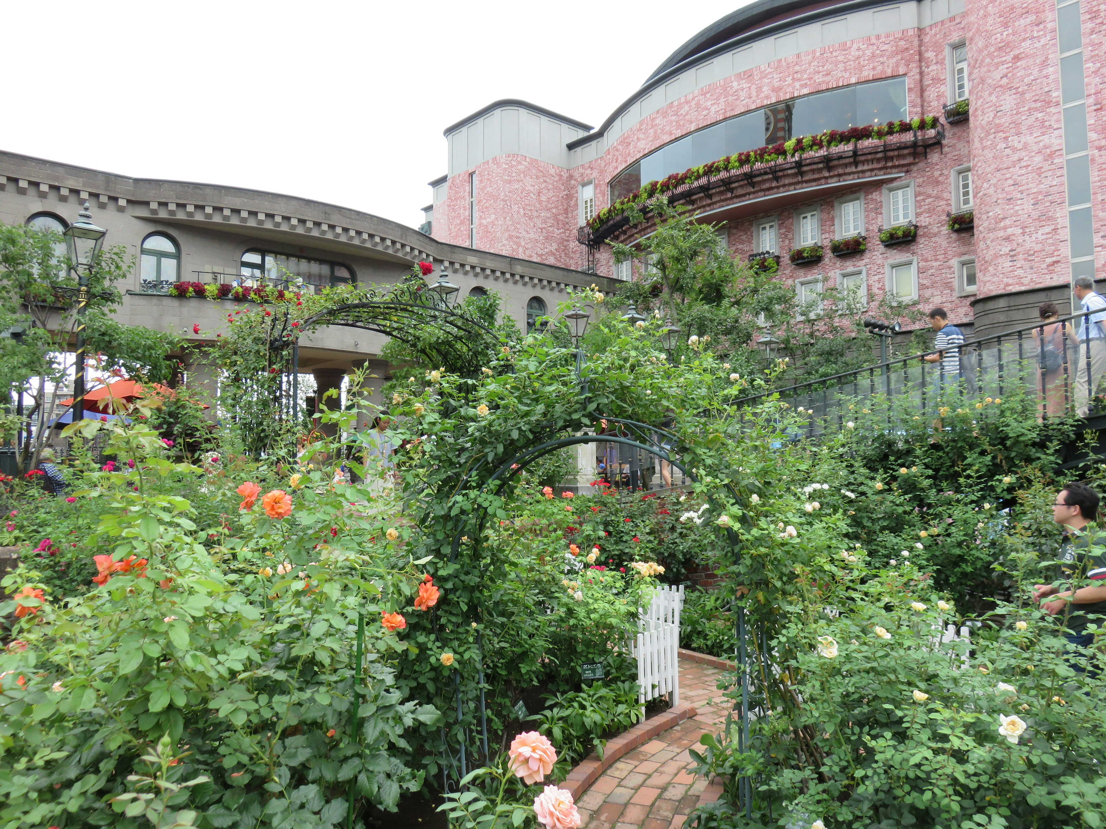 Eine malerische Gartenszene mit einem rosa Gebäude und bunten Rosen