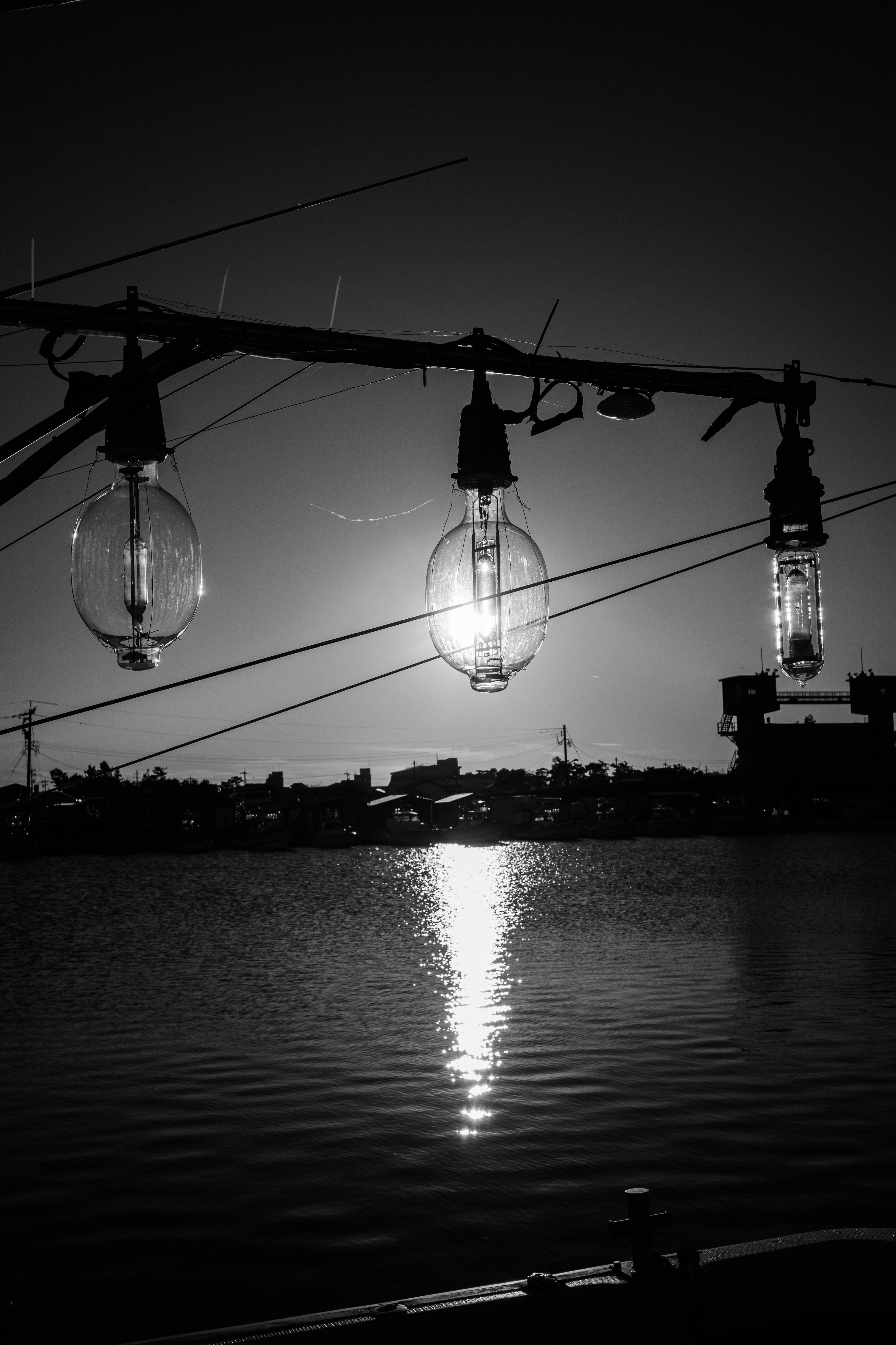 Silhouettes de lampes suspendues se reflétant sur la surface de l'eau