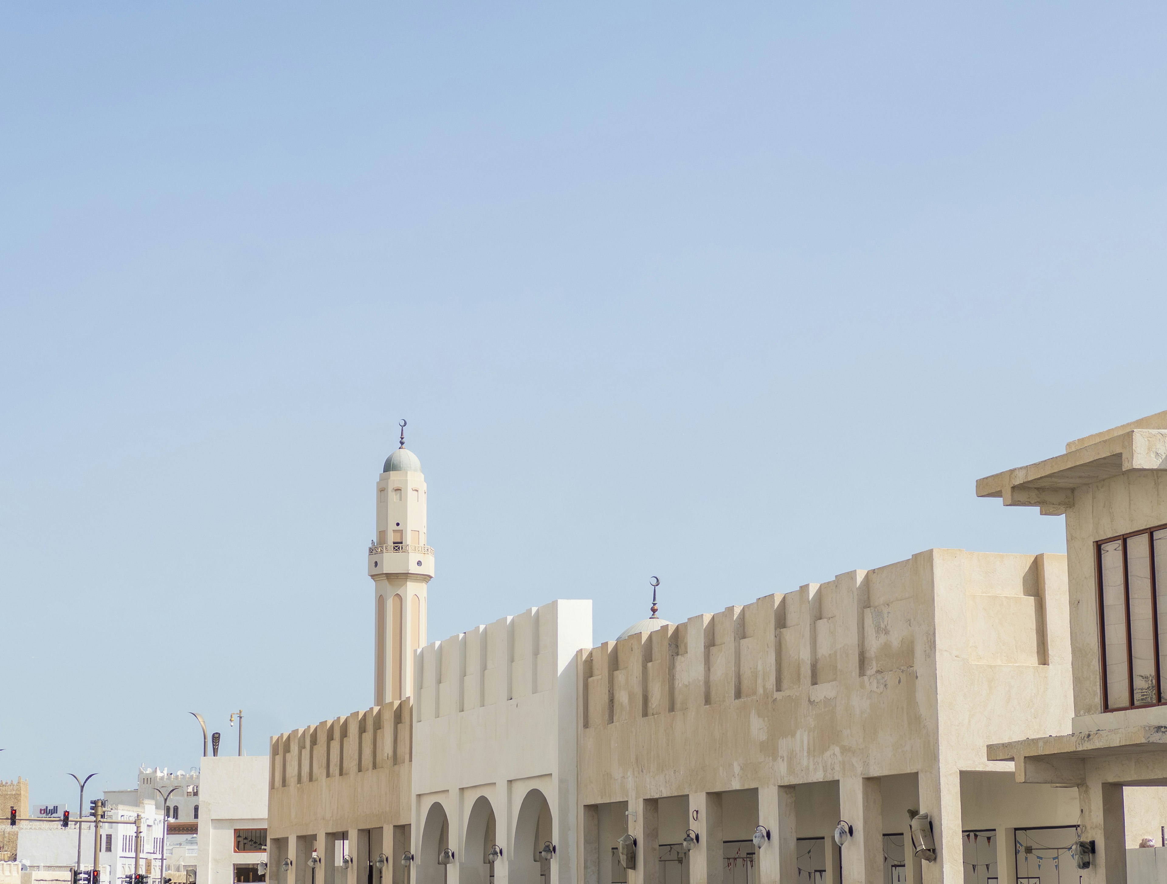 Traditional buildings and a minaret under a clear blue sky