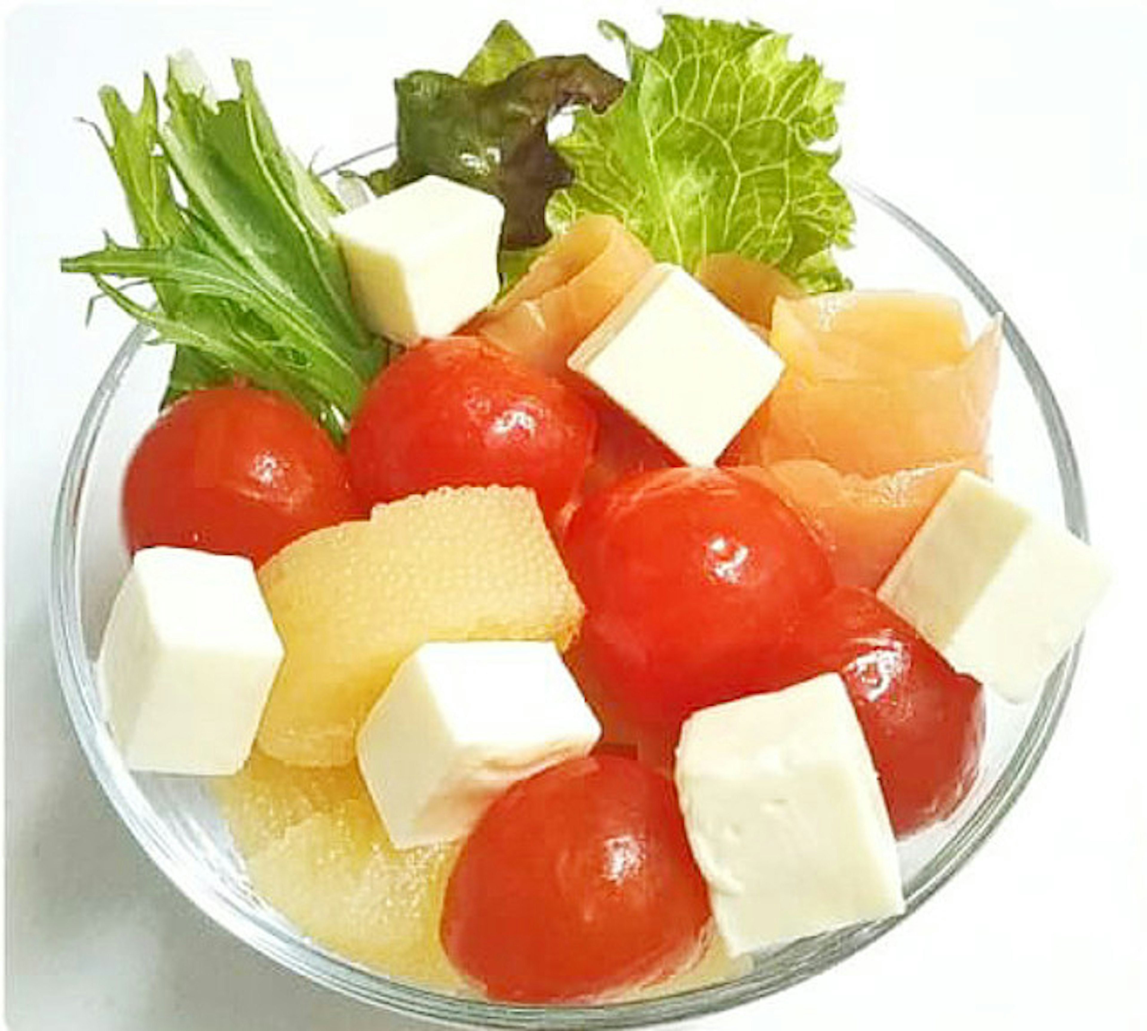 Un tazón de ensalada lleno de tomates cherry queso mozzarella lechuga y compota de frutas