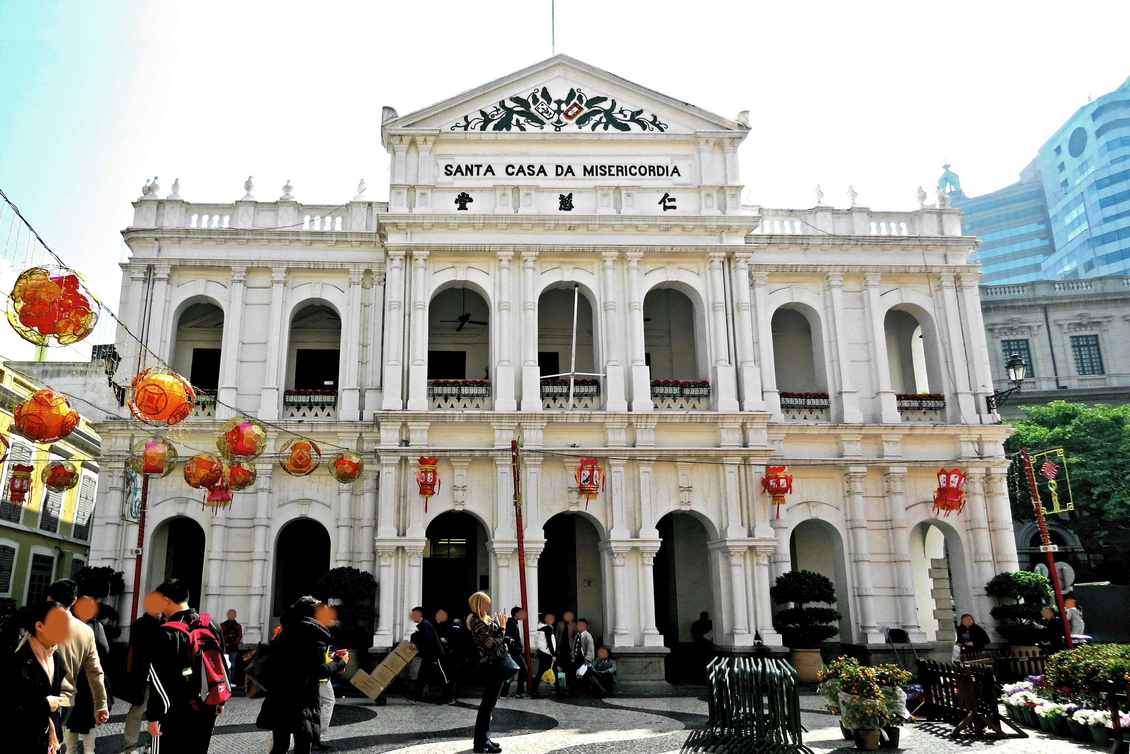 อาคารประวัติศาสตร์พร้อมโคมไฟสีสันสดใสในจัตุรัสที่มีชีวิตชีวา